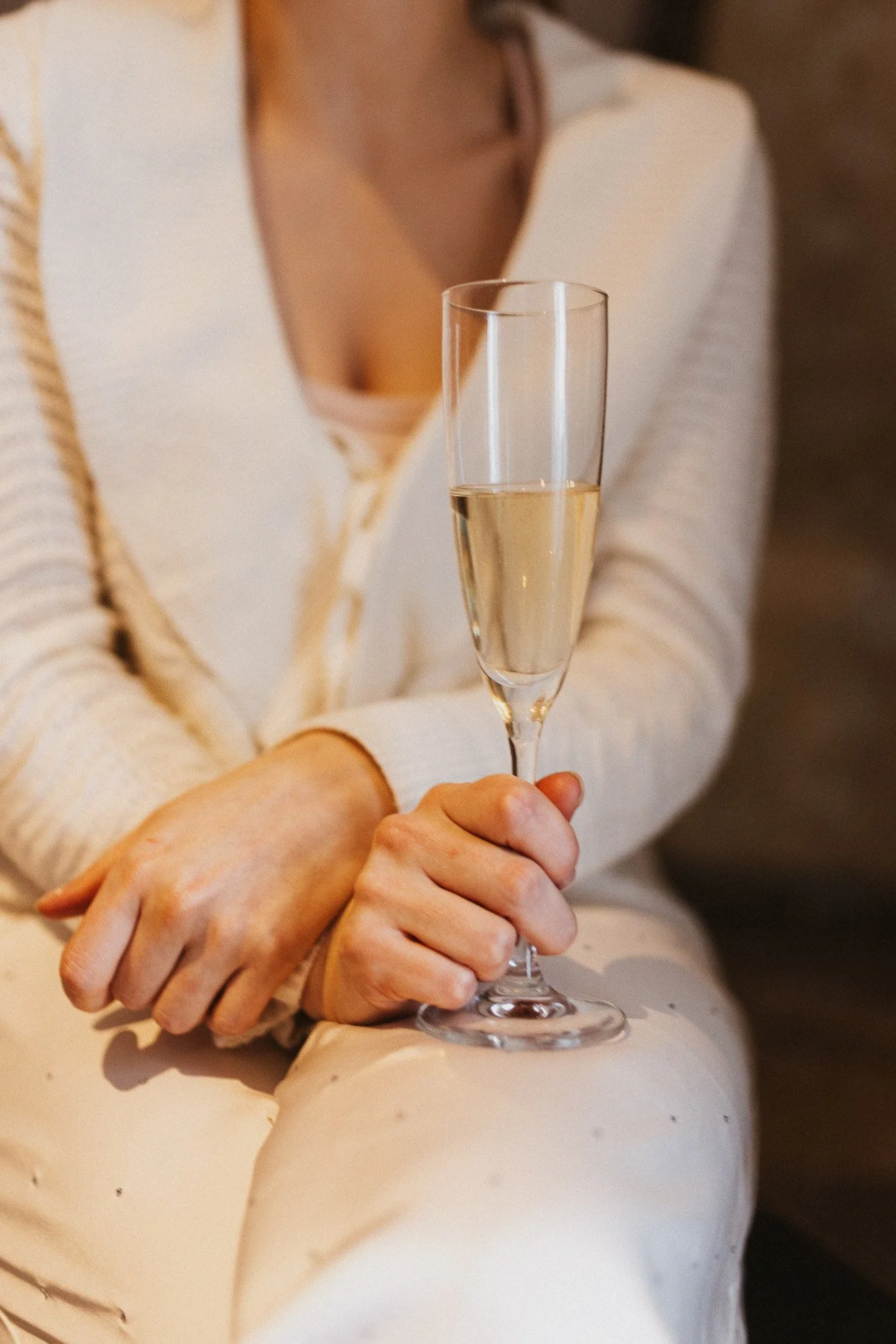 Detailaufnahme eines ruhigen Moments mit Sektglas während der Winterhochzeit.