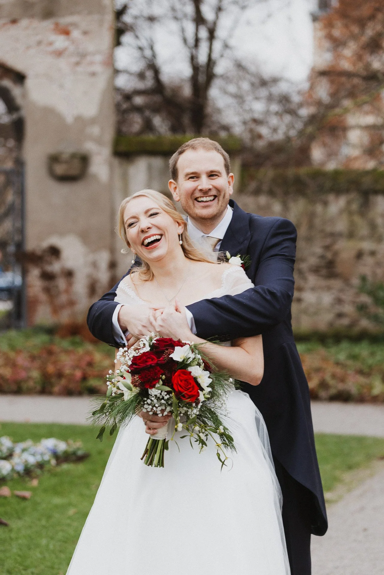 Natürliches Paarportrait von Elisabeth und Niklas mit Blumenstrauß nach der Trauung.
