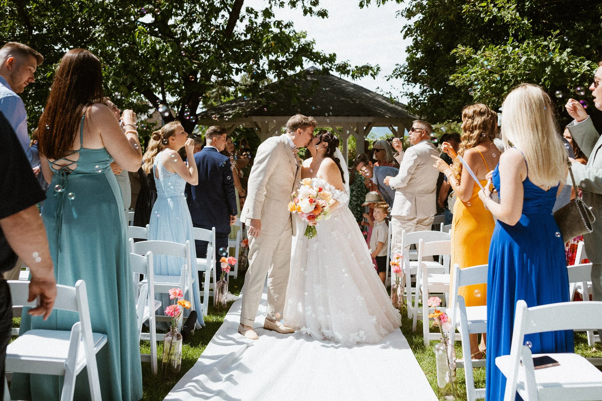 Brautpaar wird beim Auszug von jubelnden Gästen begleitet.