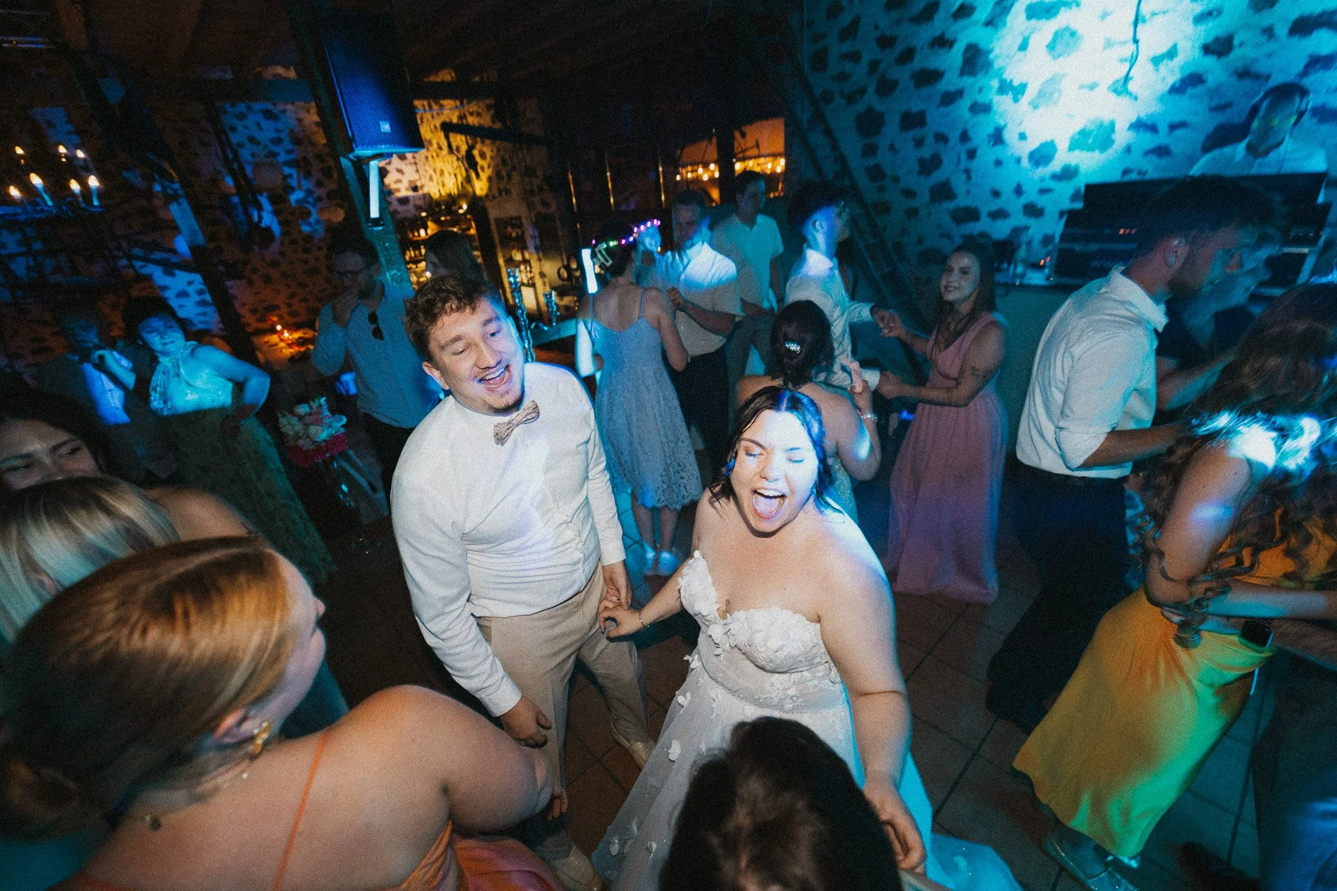 Brautpaar tanzt gemeinsam mit den Gästen während der Hochzeitsfeier.
