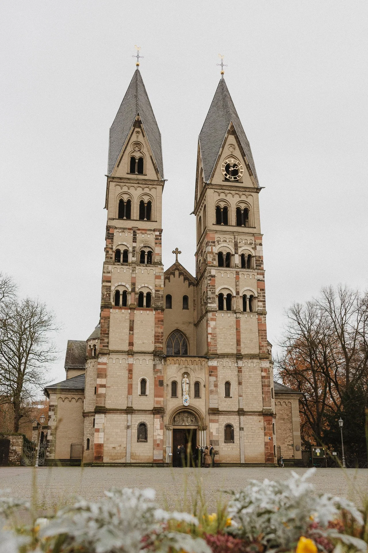 Außenansicht der Kirche Basilika Sankt Kastor während der Winterhochzeit von Elisabeth und Niklas.
