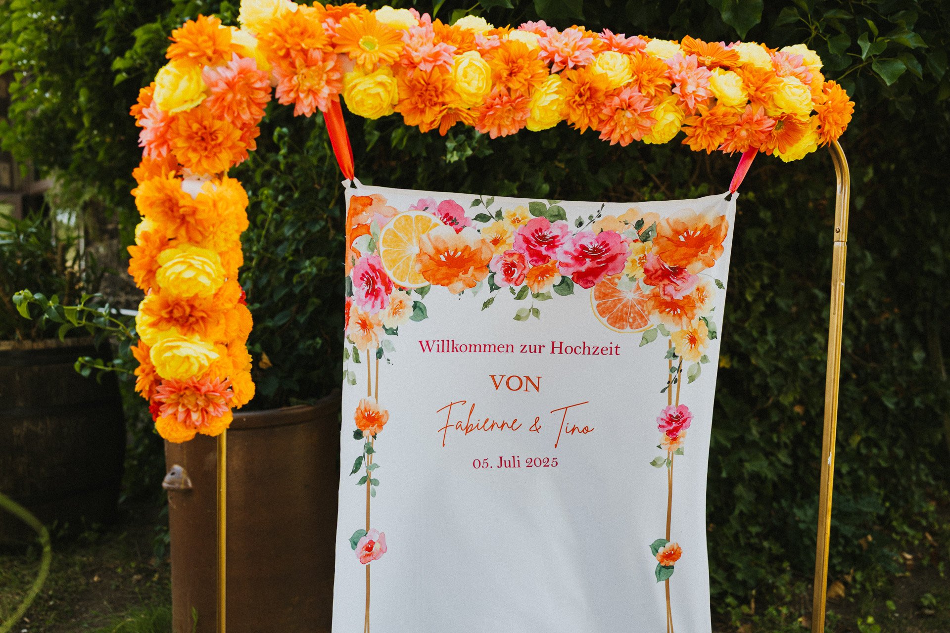Willkommensschild zur Hochzeit von Fabienne und Tino mit sommerlicher Blumendekoration.