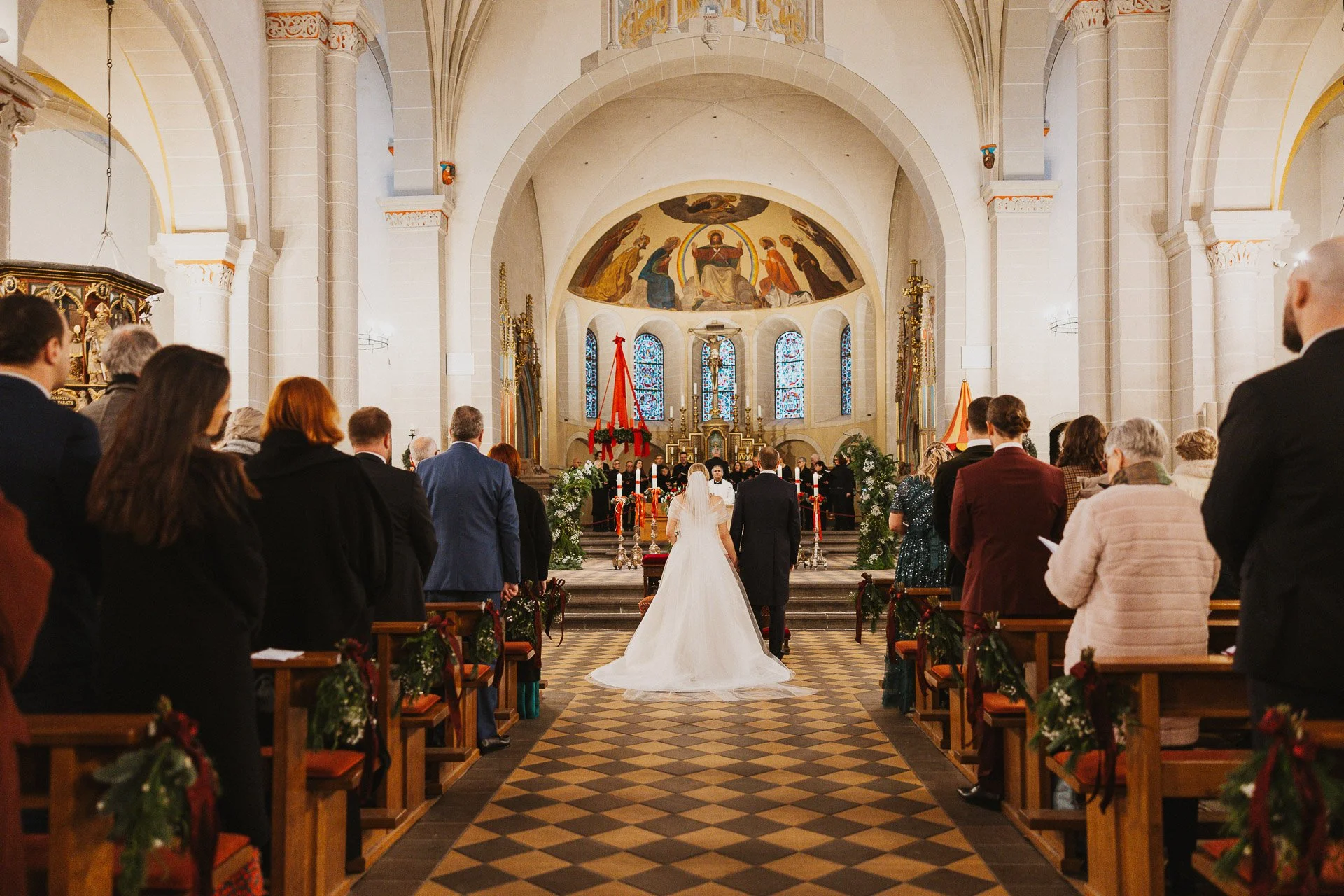 Das Brautpaar Elisabeth und Niklas beim Gang durch den Mittelgang der Kirche.
