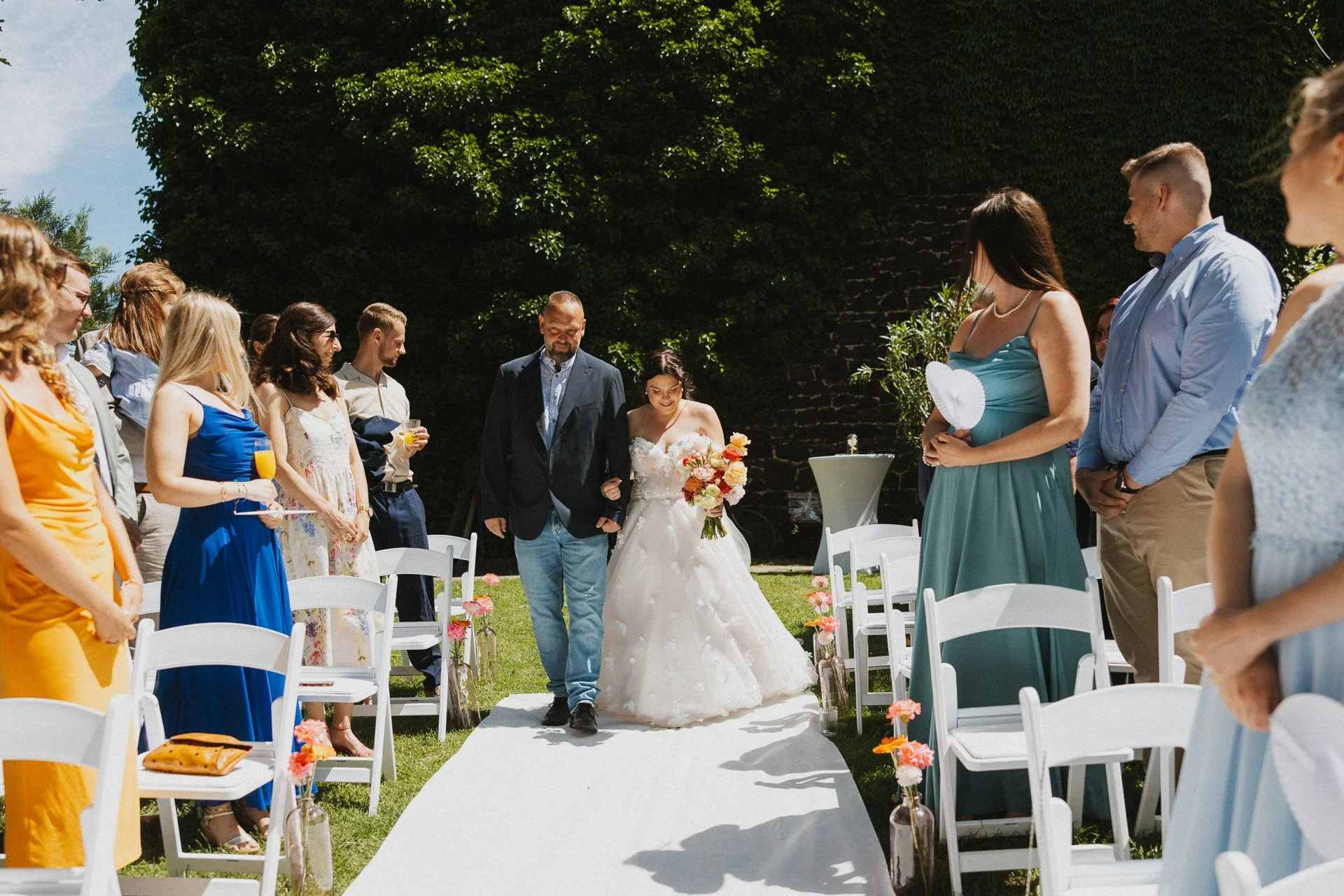 Braut zieht zum Beginn der freien Trauung unter freiem Himmel ein.