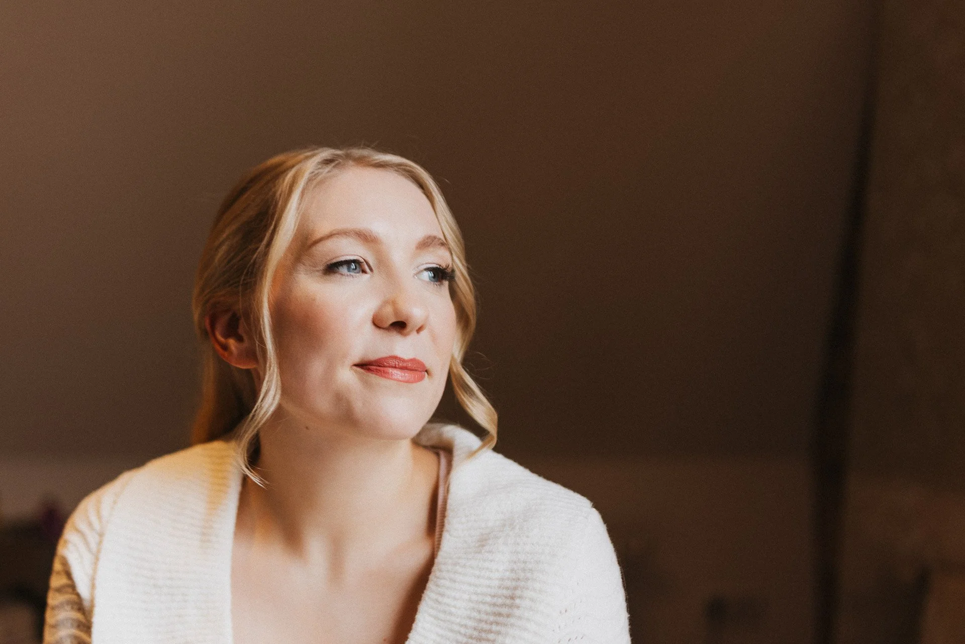 Nahes Portrait der Braut Elisabeth mit natürlichem Licht während der Hochzeitsvorbereitungen.
