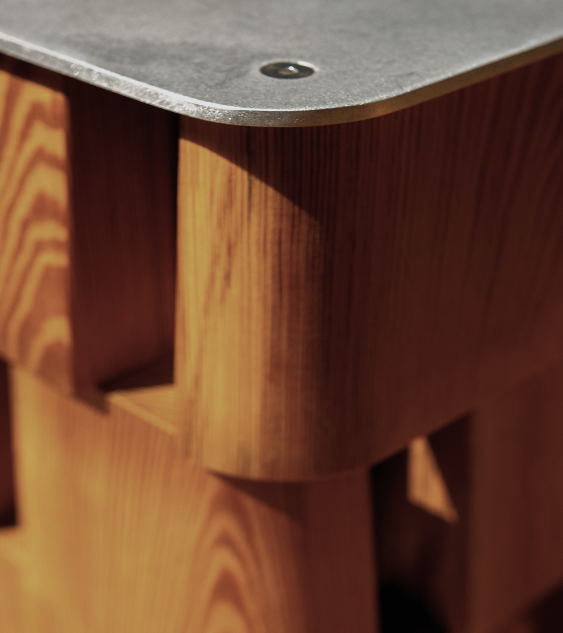 Close-up of a wooden speaker with a metal top panel.