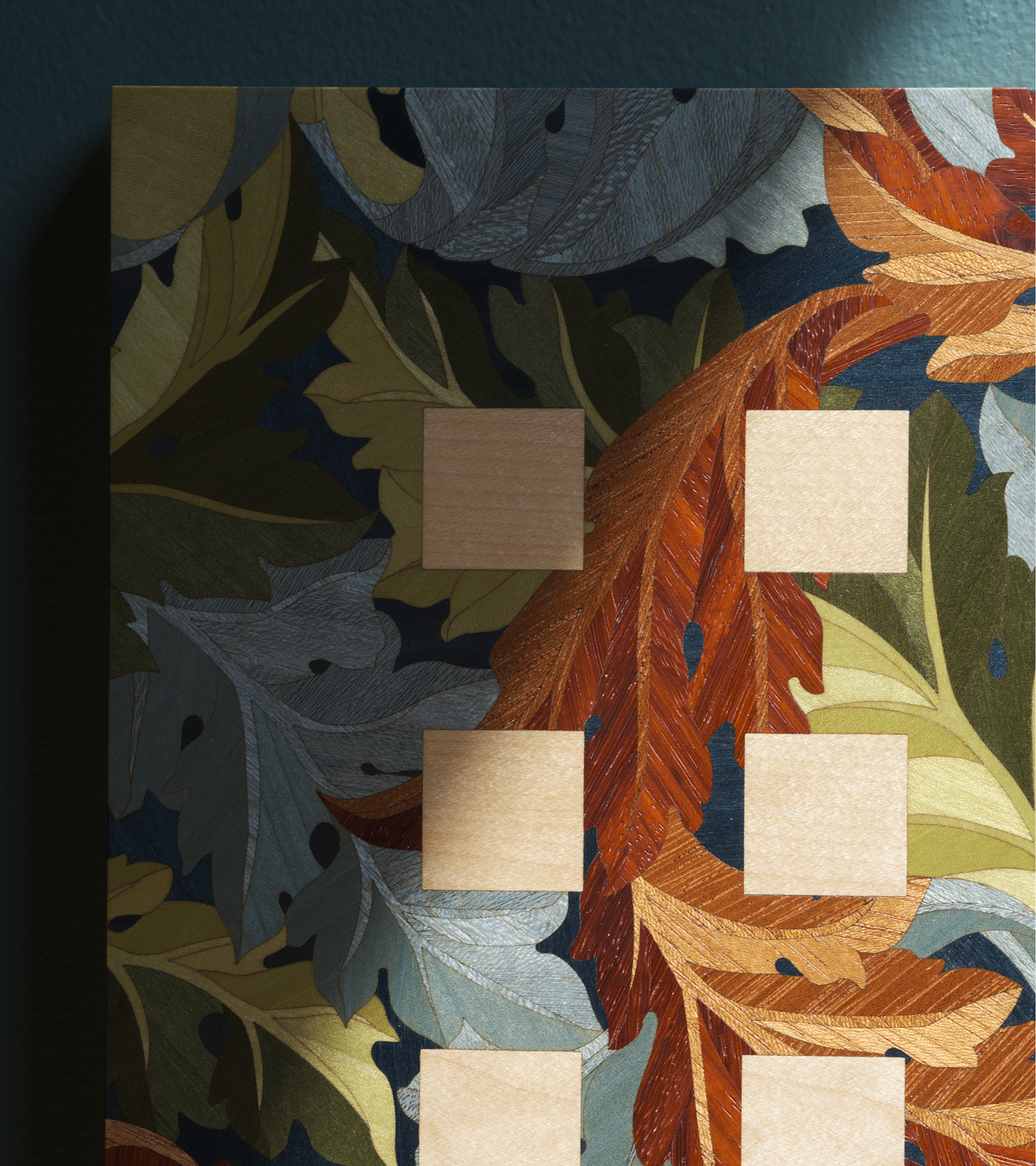 A decorative wall with autumn leaves design and blank photo slots.