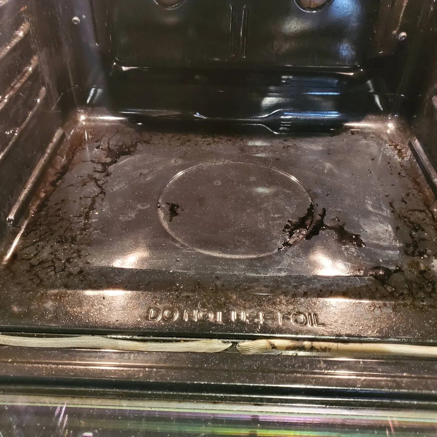 Cleaned oven interior with no food or residue, stainless steel surface, visible heating element, and a circular heating element at the center.