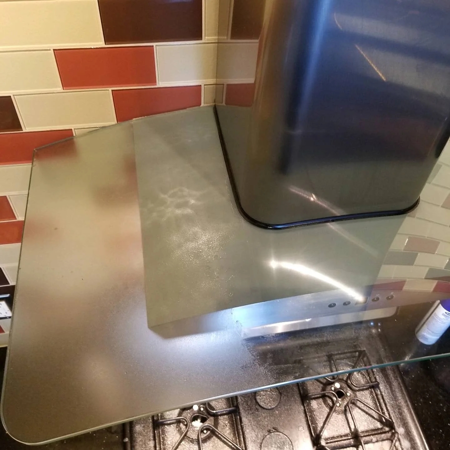 A kitchen range hood that is coated in grease and grime.