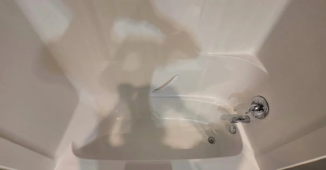 Empty white bathtub that was cleaned of major dirt and grime