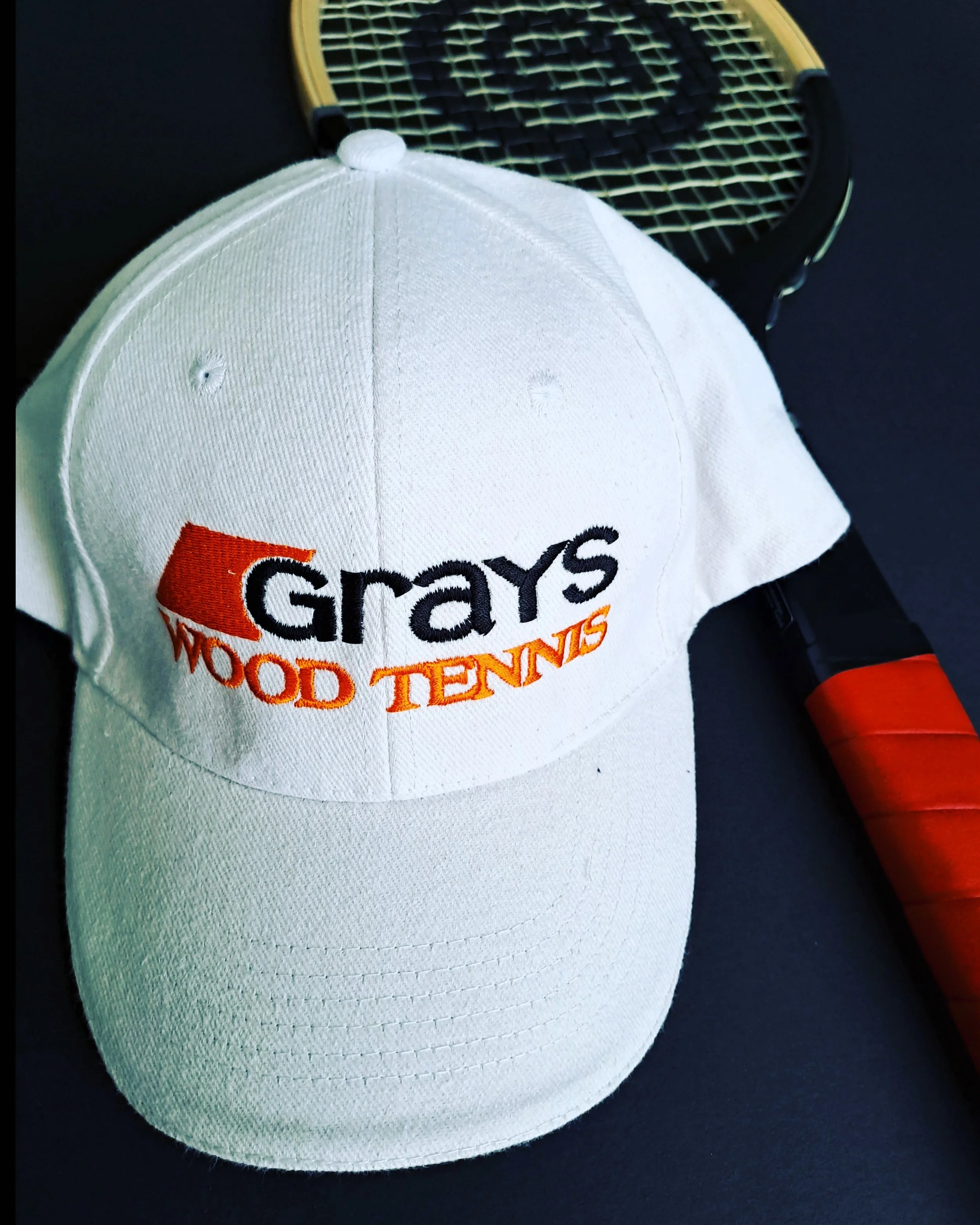 A Grays Wood Tennis cap with a Grays wooden racket in the background.
