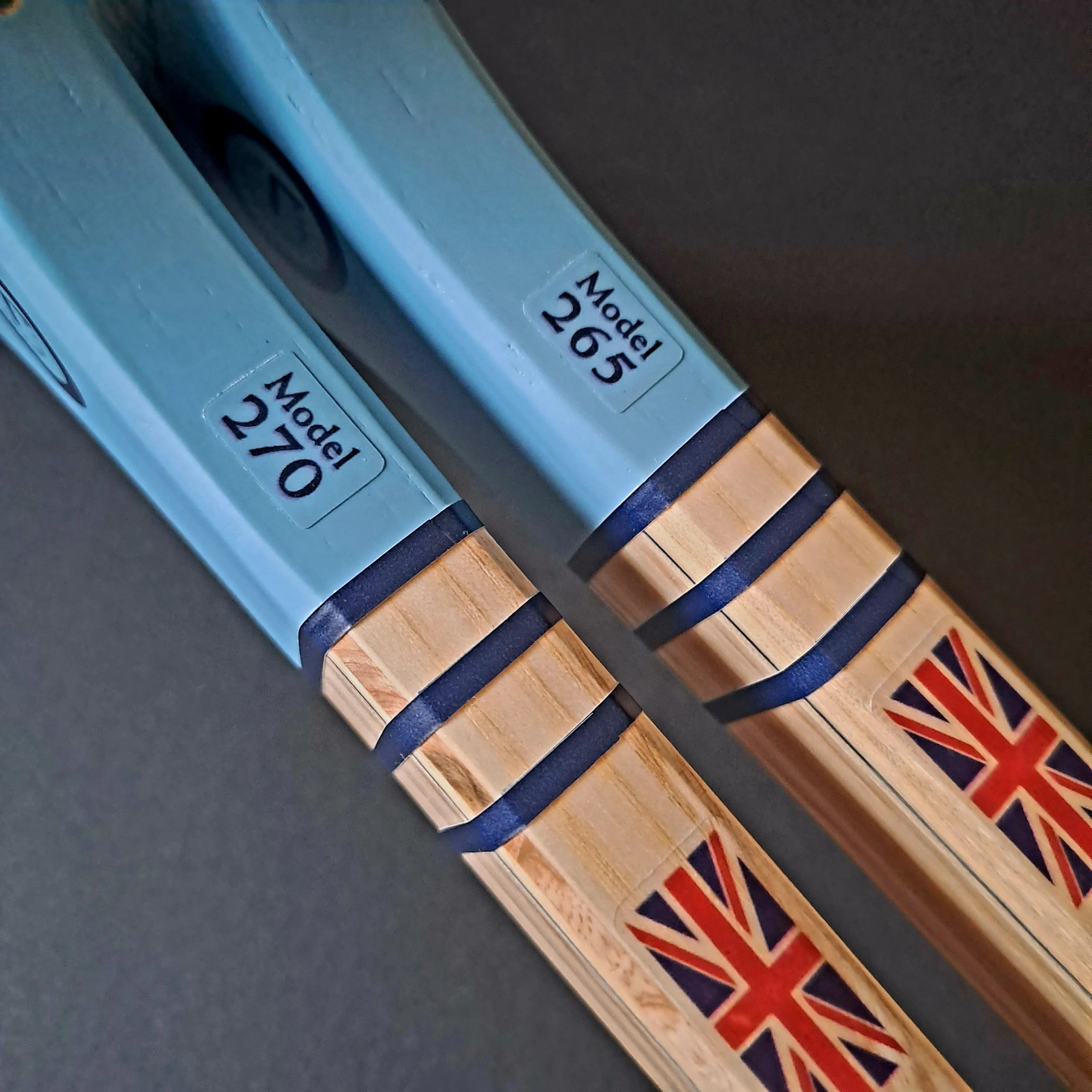 Side shaft views of two Grays Eco-Blue rackets against a black background