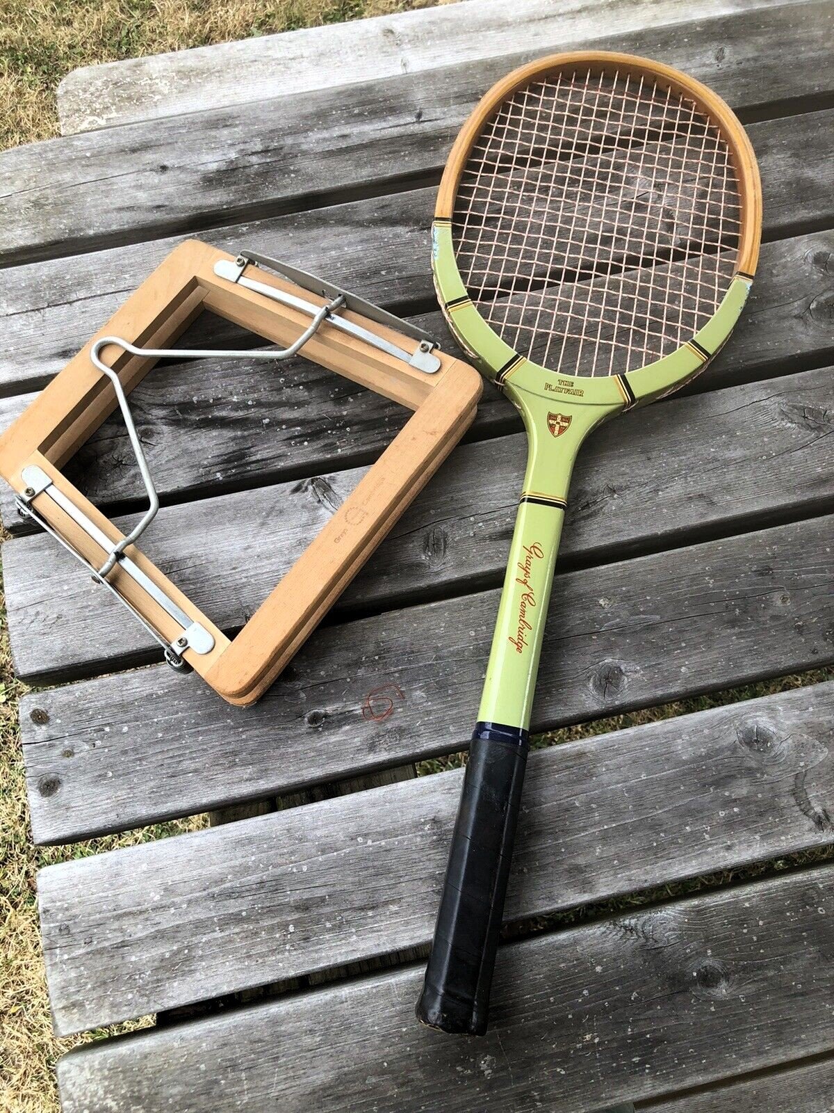 Heritage Grays racket and press on a wooden table.