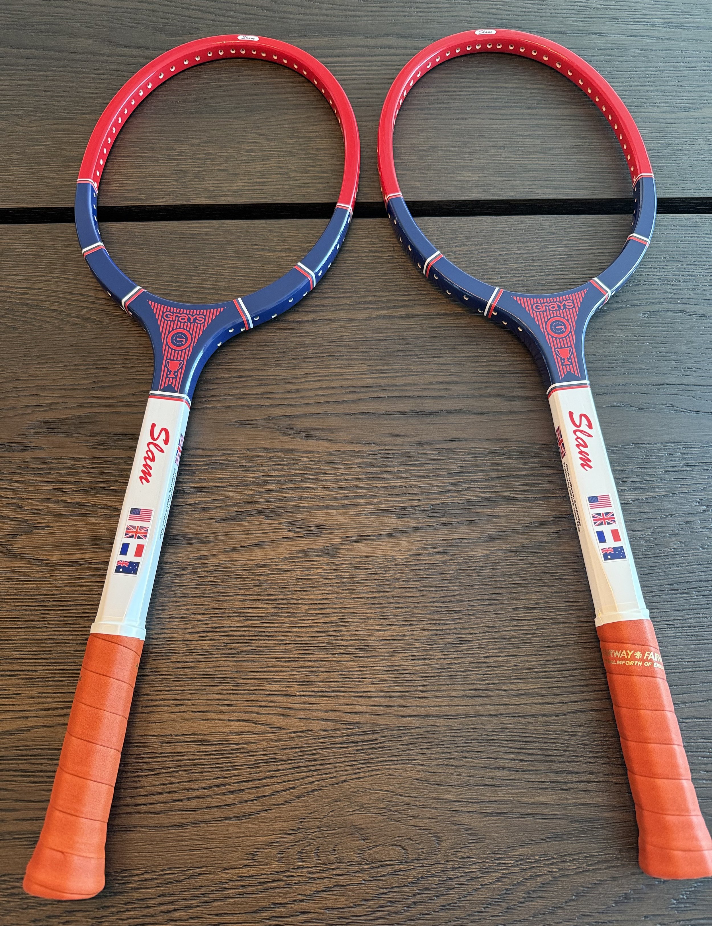 Two unstrung Slam frames on wooden bench.