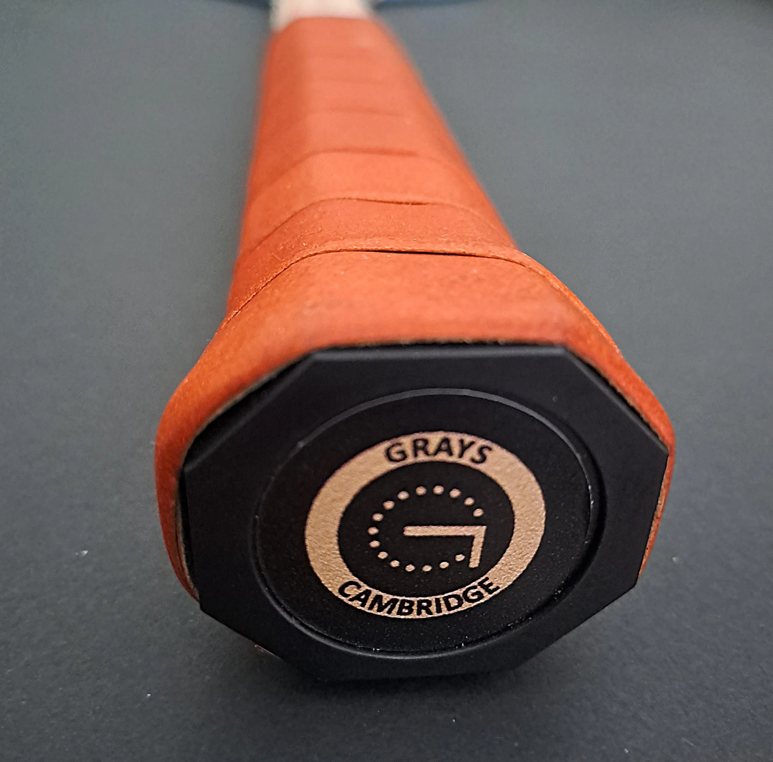 View of butt cap and grip of Grays Eco-Blue racket against a black background