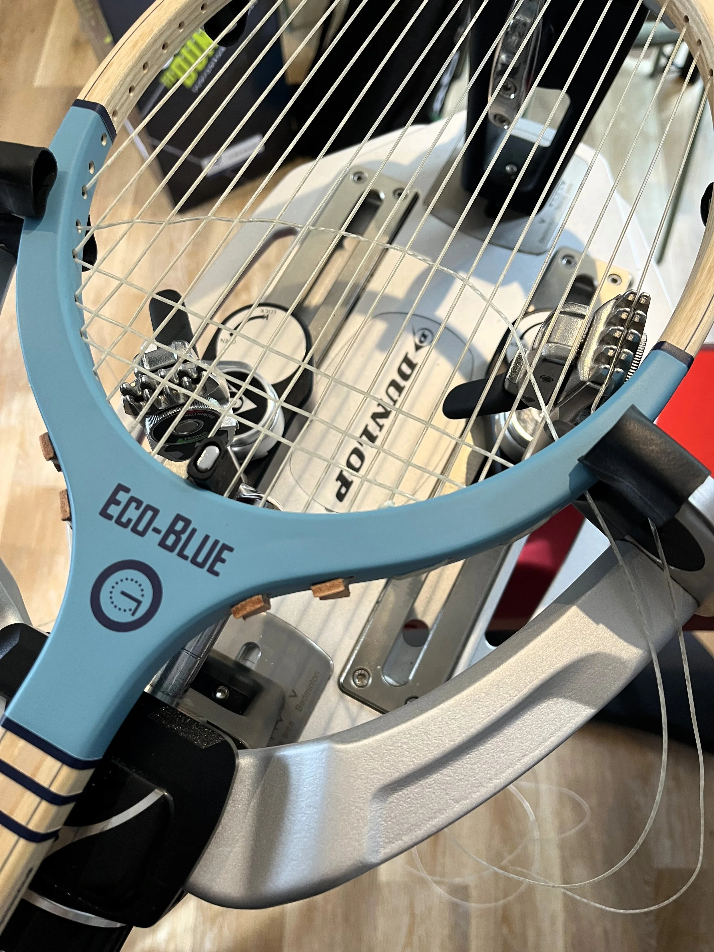 Grays Eco-Blue racket on a stringing machine being strung.