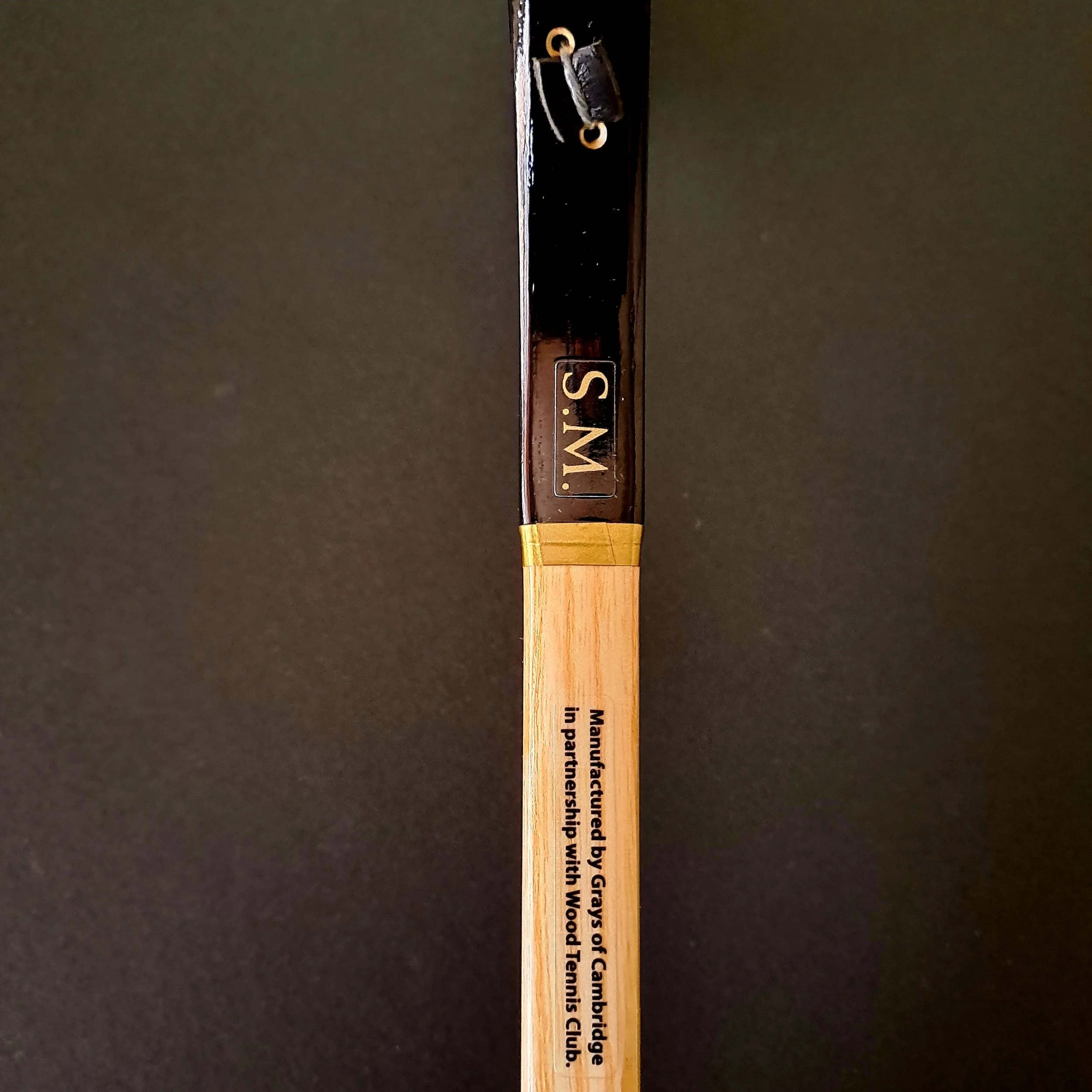 side view of racket shaft and throat showing decals on black background