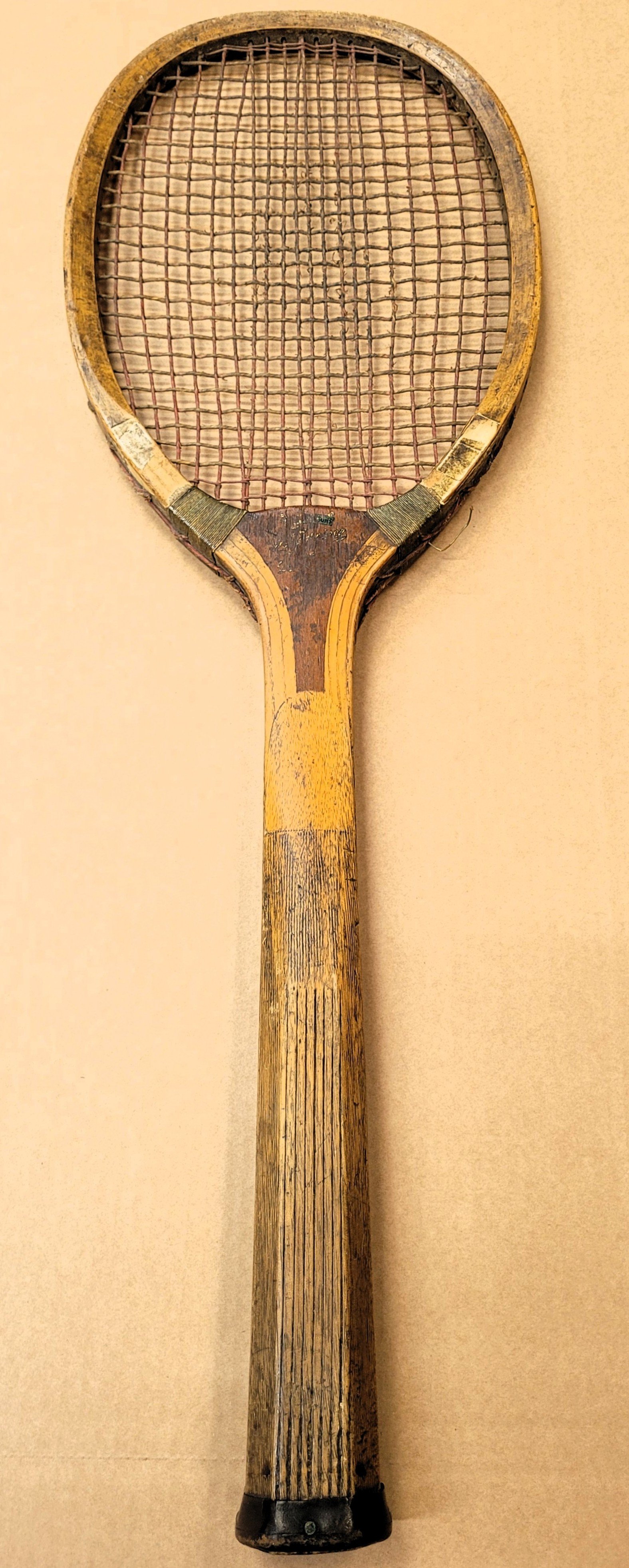 Photo of antique Grays racket against a light brown background
