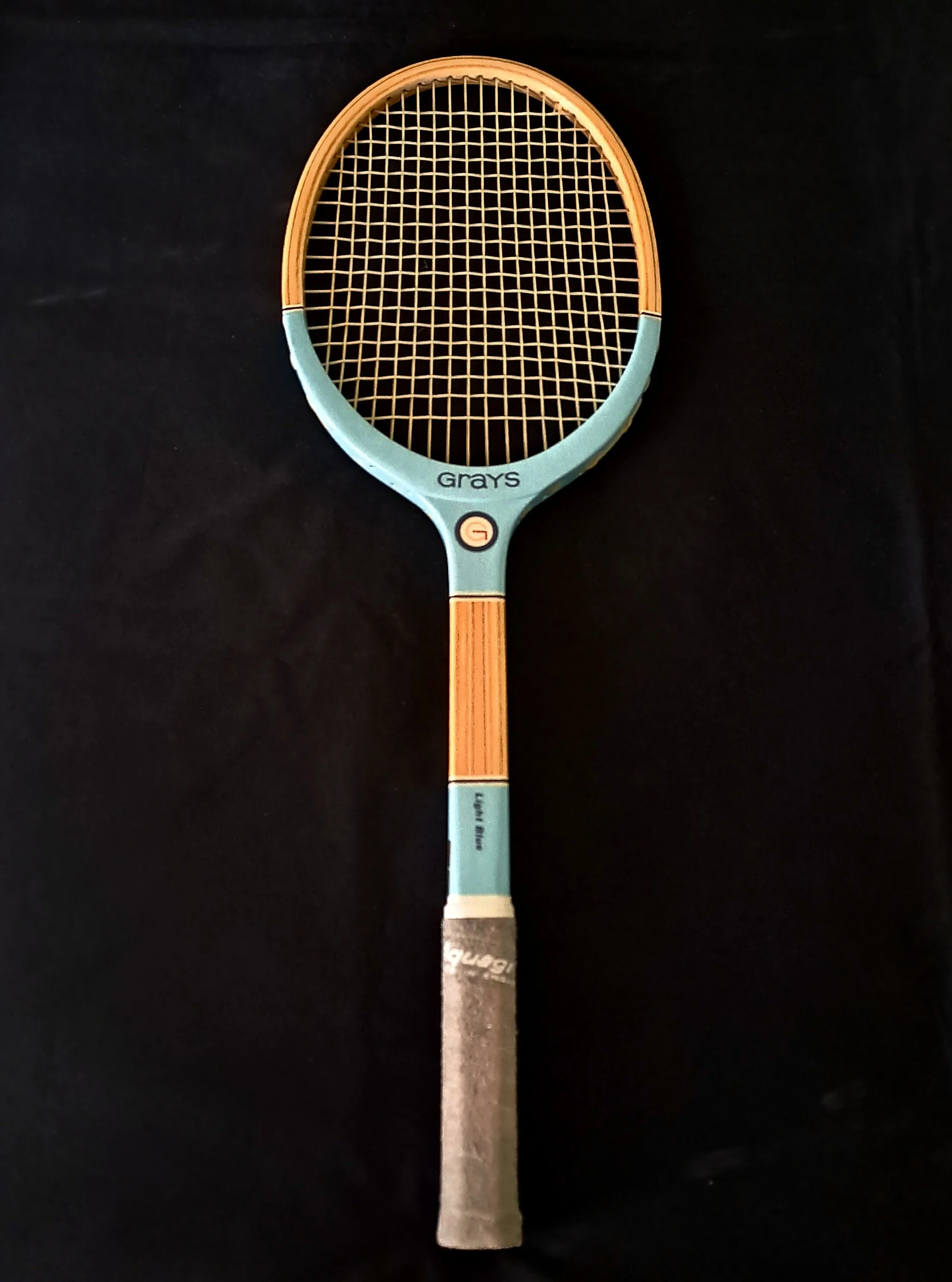 Grays Light Blue tennis racket against black background.