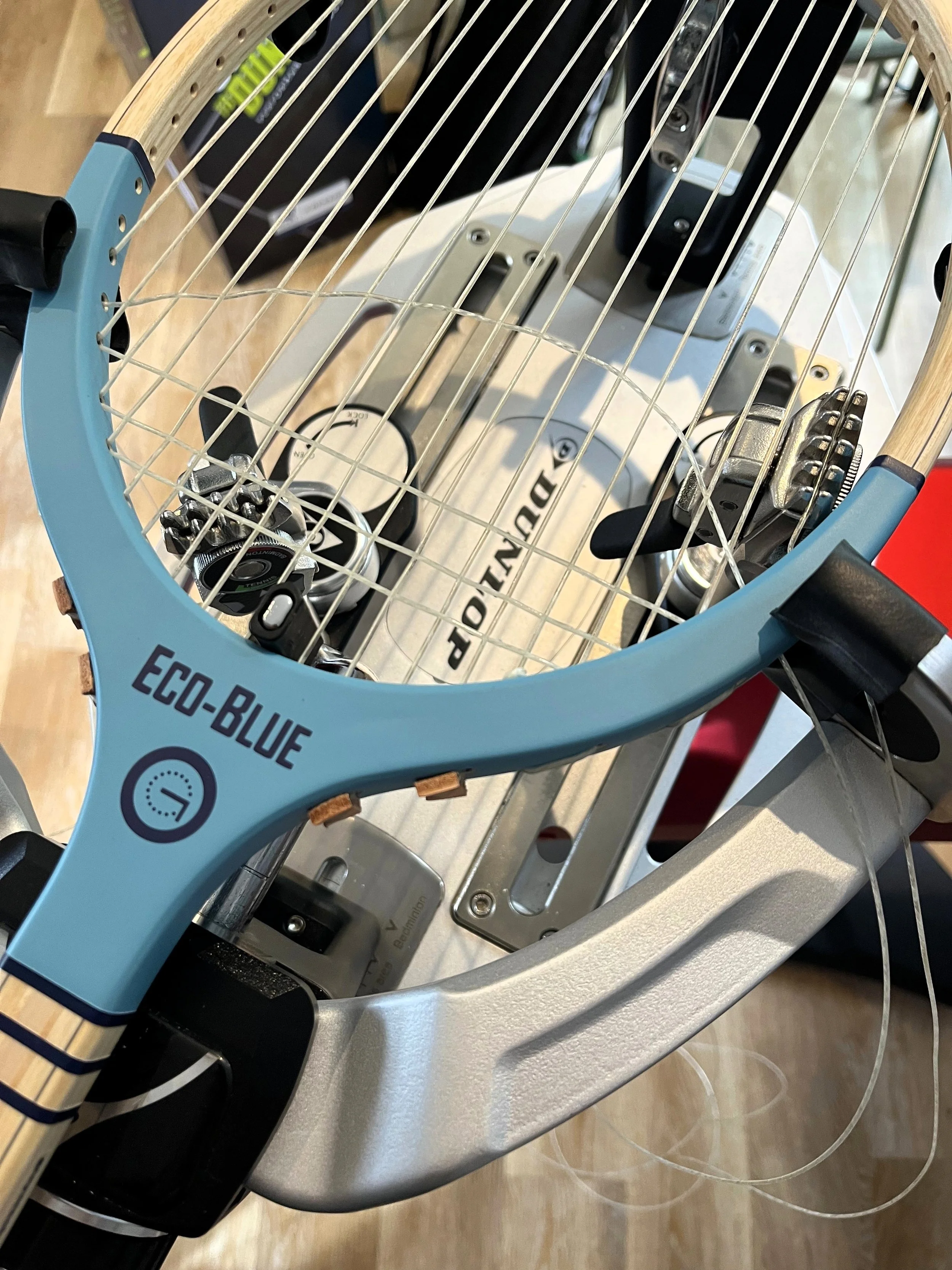 Grays Eco-Blue wood racket mounted in a stringing machine