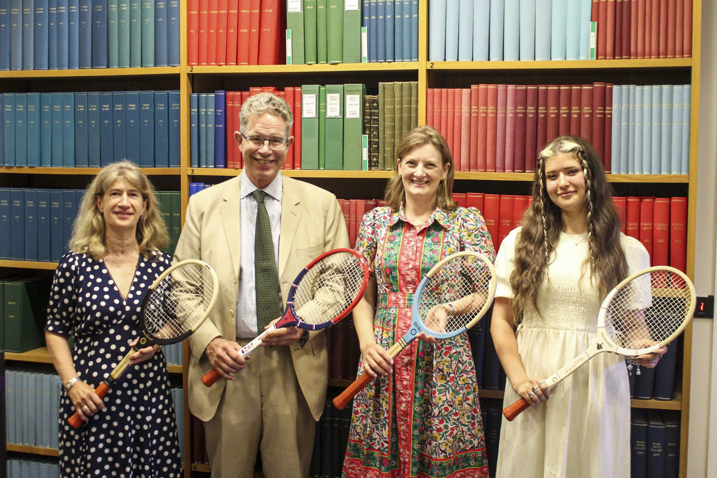 four people inside Wimbledon library holding Grays rackets