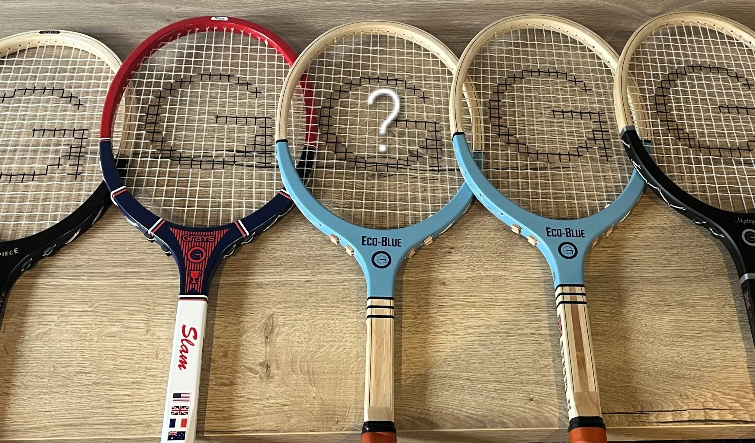 Grays rackets on a wood surface with a question mark in the centre.