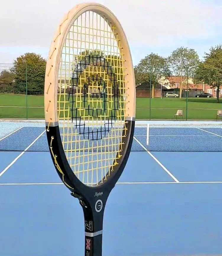 head of Grays racket with tennis court behind