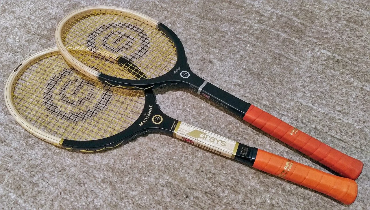 Two Grays rackets resting on a carpet floor.