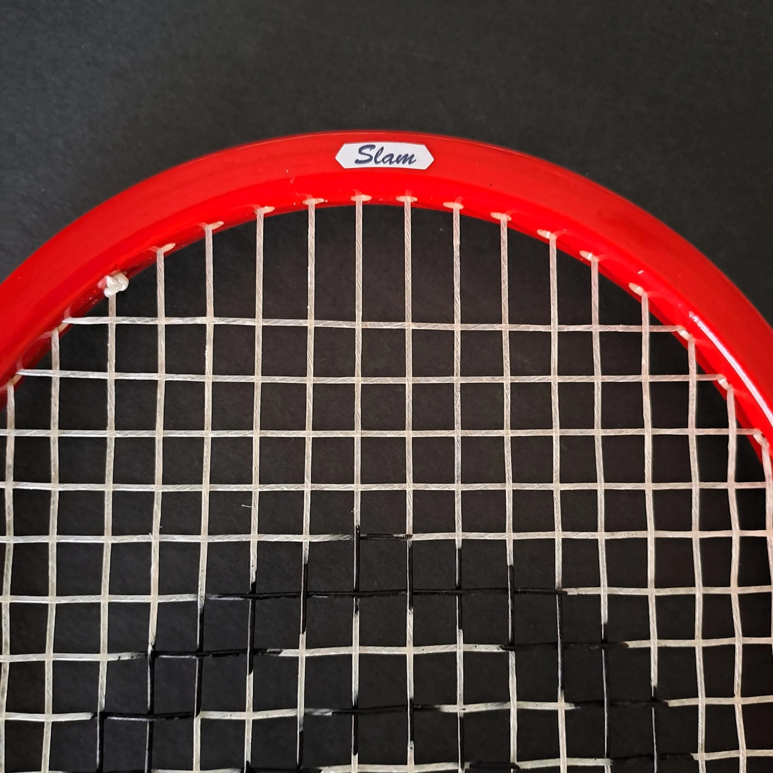 Close-up of Grays Slam head showing stringing and top frame cosmetic.