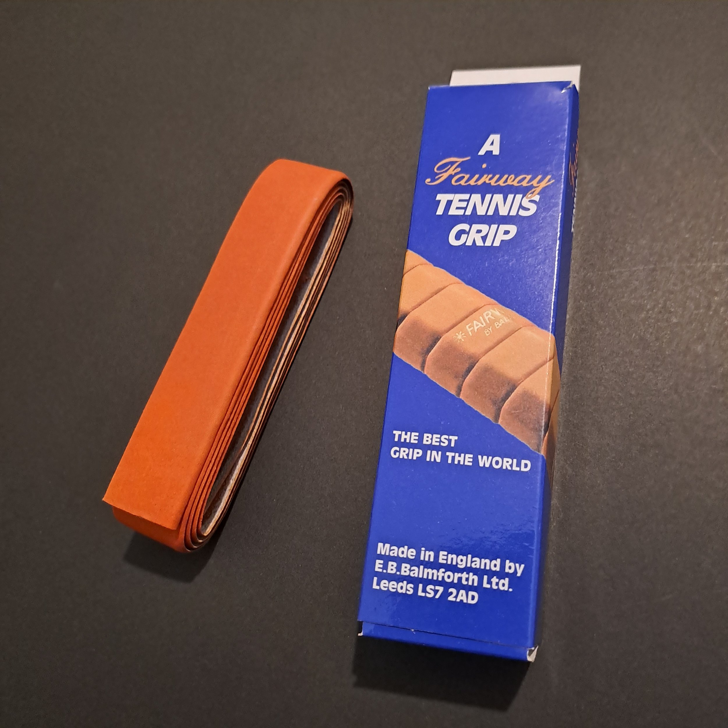 Tennis grip and packet displayed against black background