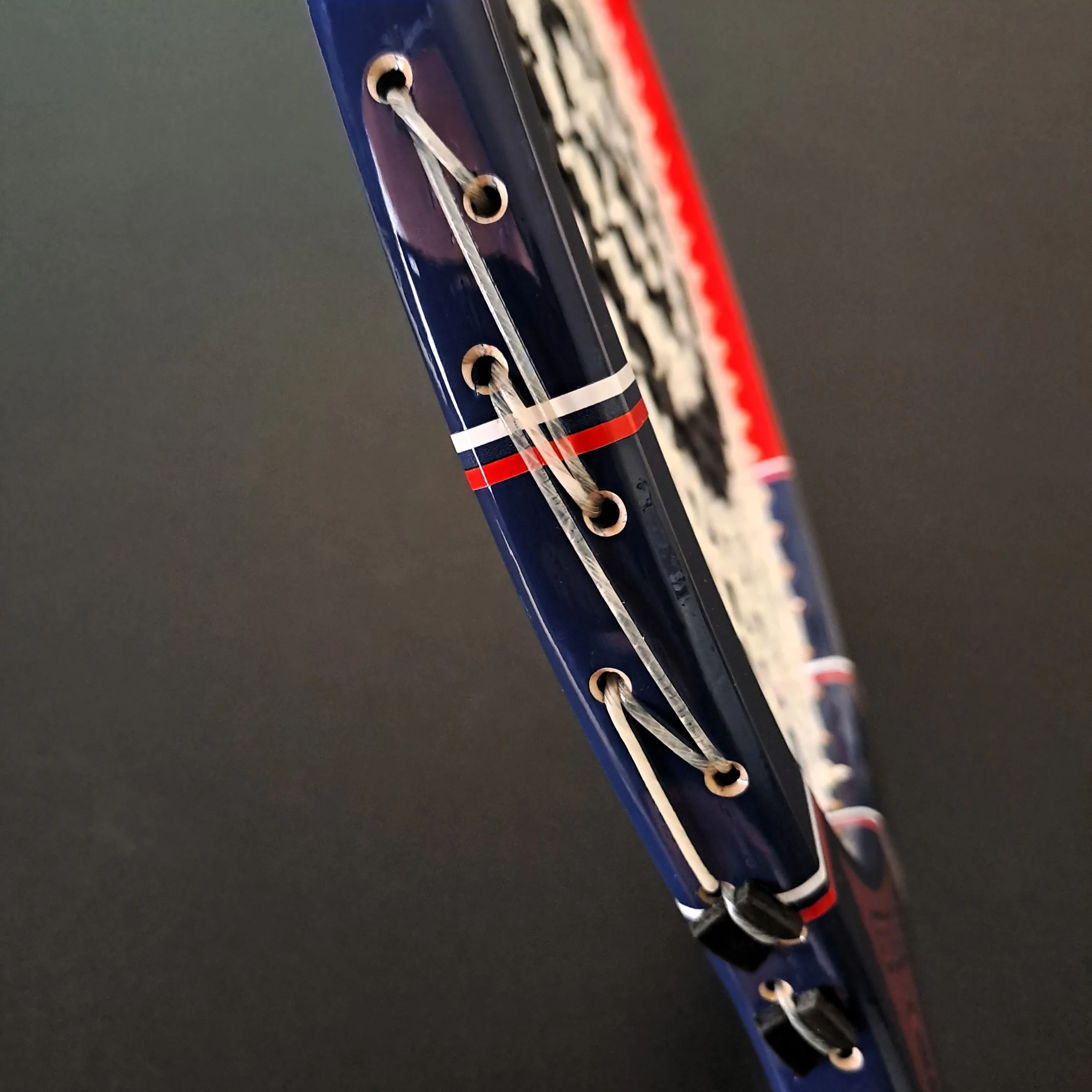 Close-up of Grays Slam side frame showing stringing.