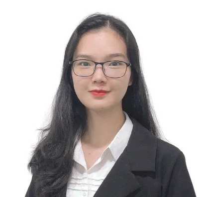 A woman with long dark hair, wearing glasses and a black blazer over a white shirt, against a white background.