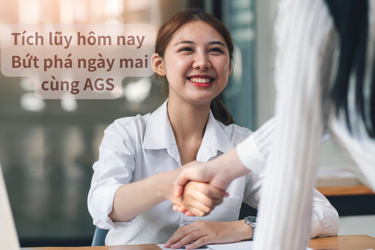 A woman smiling and shaking hands with another person in a professional setting