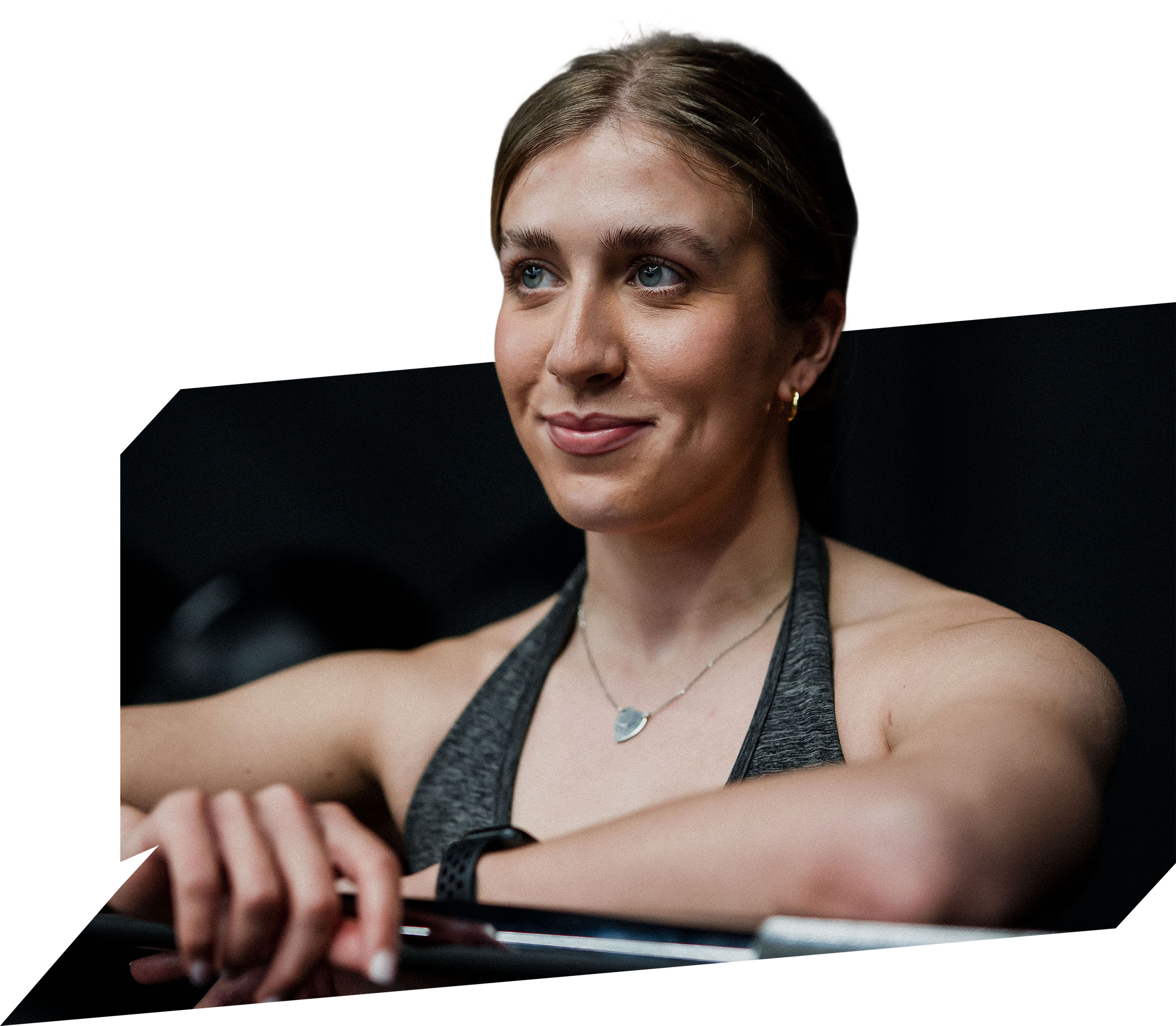 Lottie posing at a gym leaning on a barbell casually