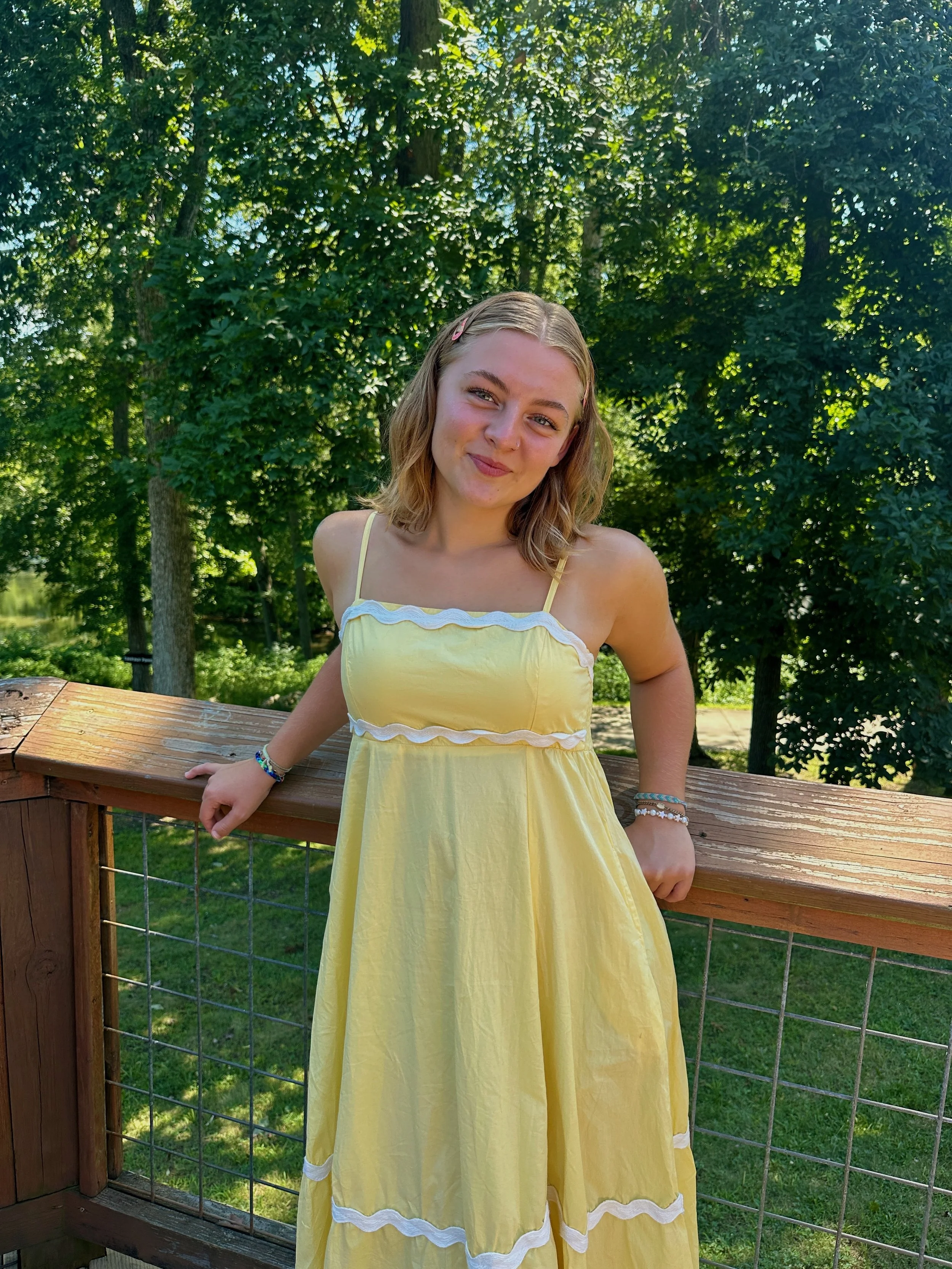 Photo of Damian Arambula, a white Latino man, wearing a blue collared shirt with pearls, standing outside
