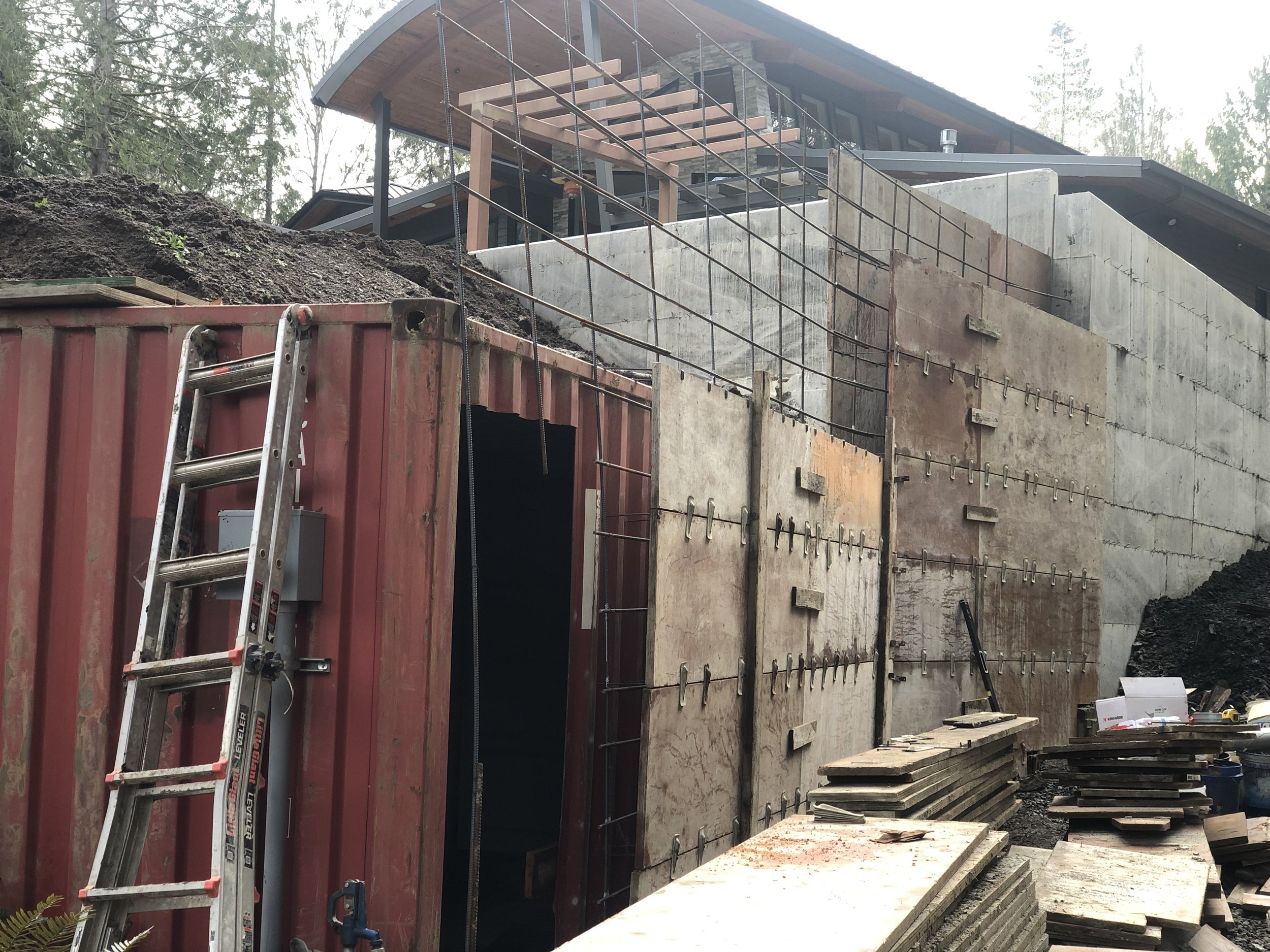 Shipping container buried in a concrete retaining wall