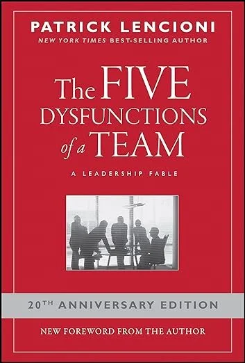 Cover of the book titled "The Five Dysfunctions of a Team" by Patrick Lencioni, 20th anniversary edition with a red background and a silhouette of a team meeting in a modern office.