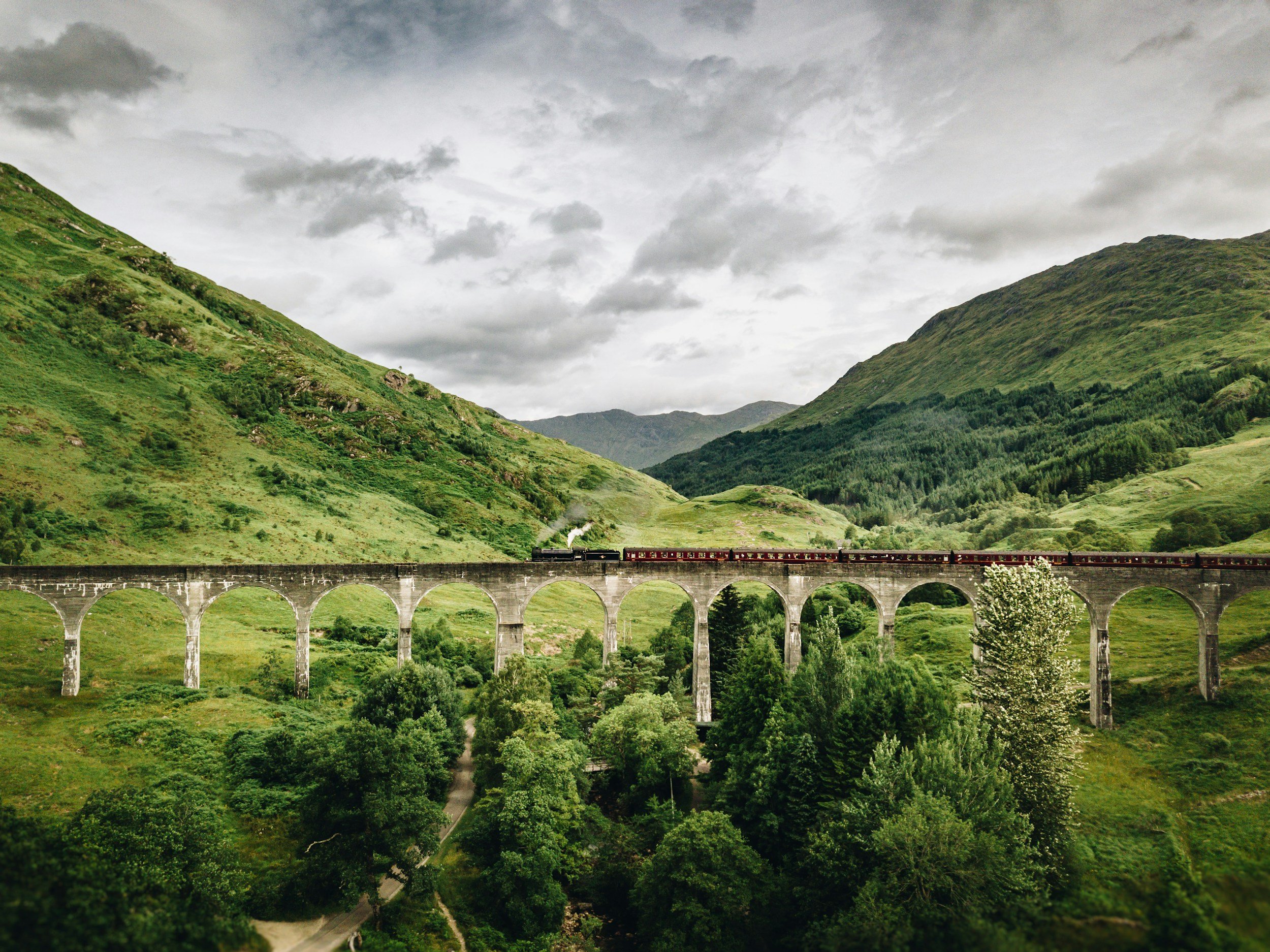 Picturesque old bride in Scottish Highlands, filled with greenery and mystery symbolizing the trend of Mystic Outlands.