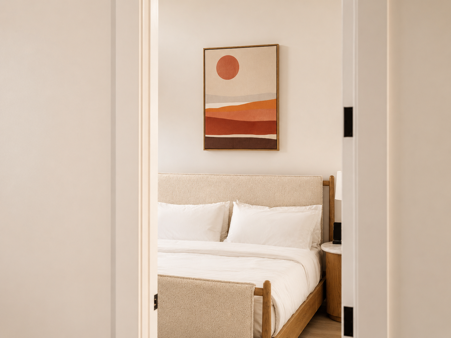 Modern bedroom with warm neutral bedding, textured headboard, and artwork selected as part of a cohesive FF&E furnishing plan.