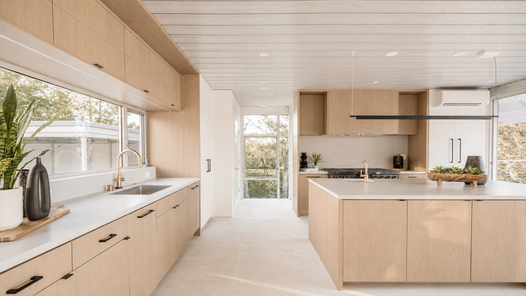 Modern kitchen with light wood cabinetry, white countertops, and minimal styling supported by furnishing and FF&E coordination.