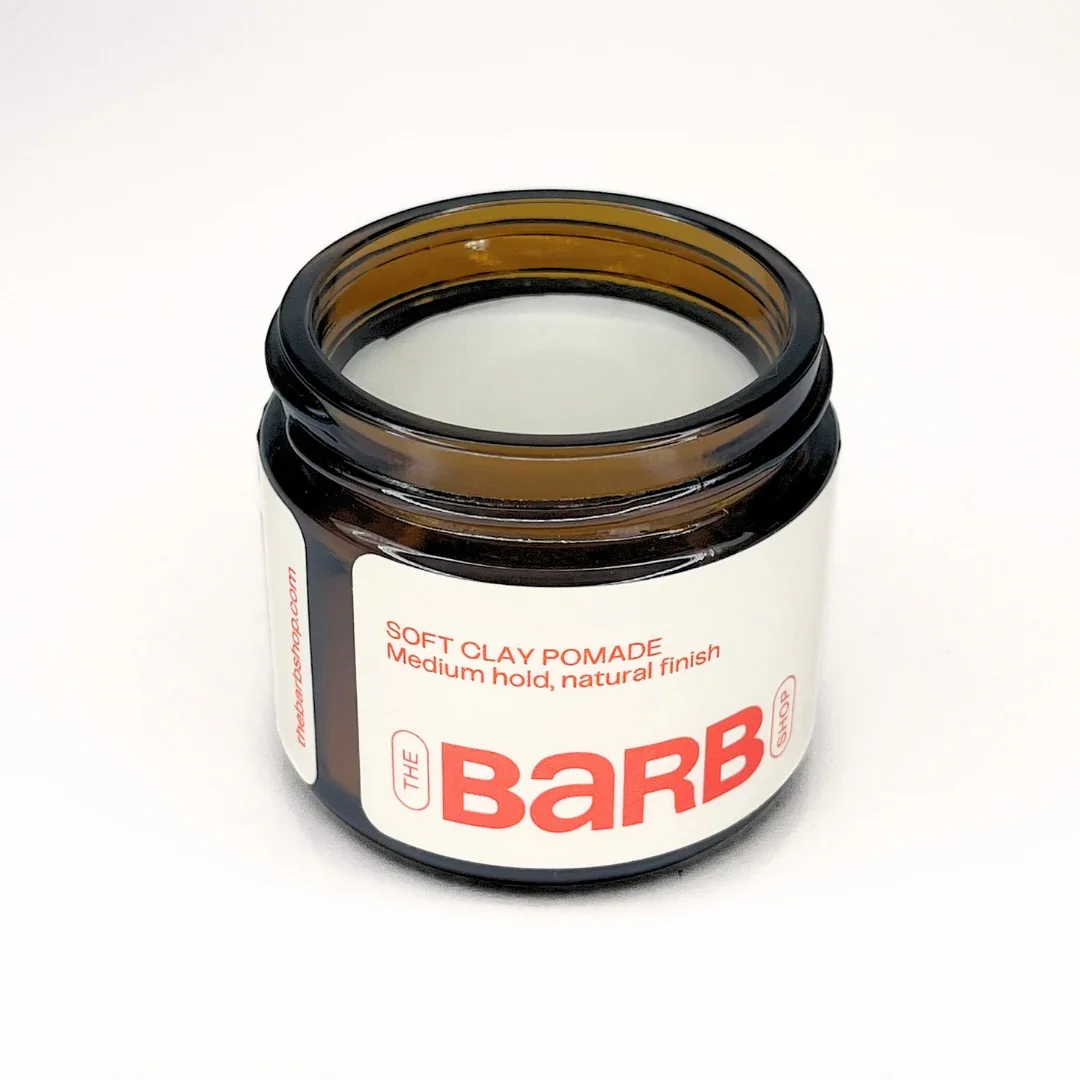 Open jar of The Barb soft clay pomade on white background