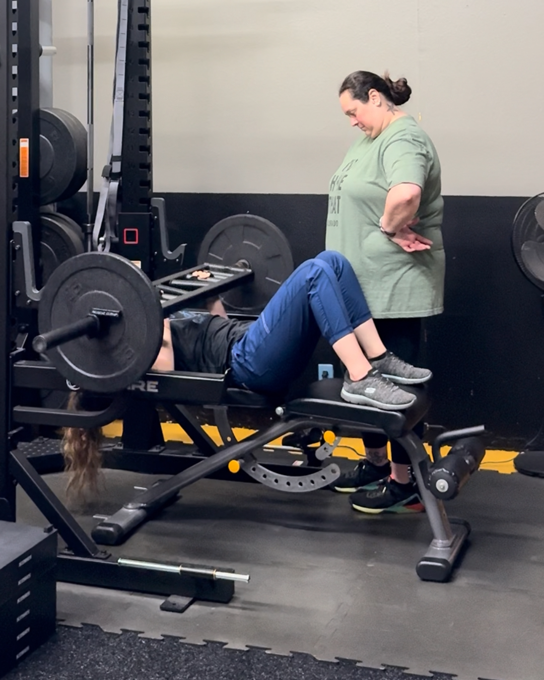 Bethany Busch coaching a client through a supported bench press, modeling strength with care in a private session.