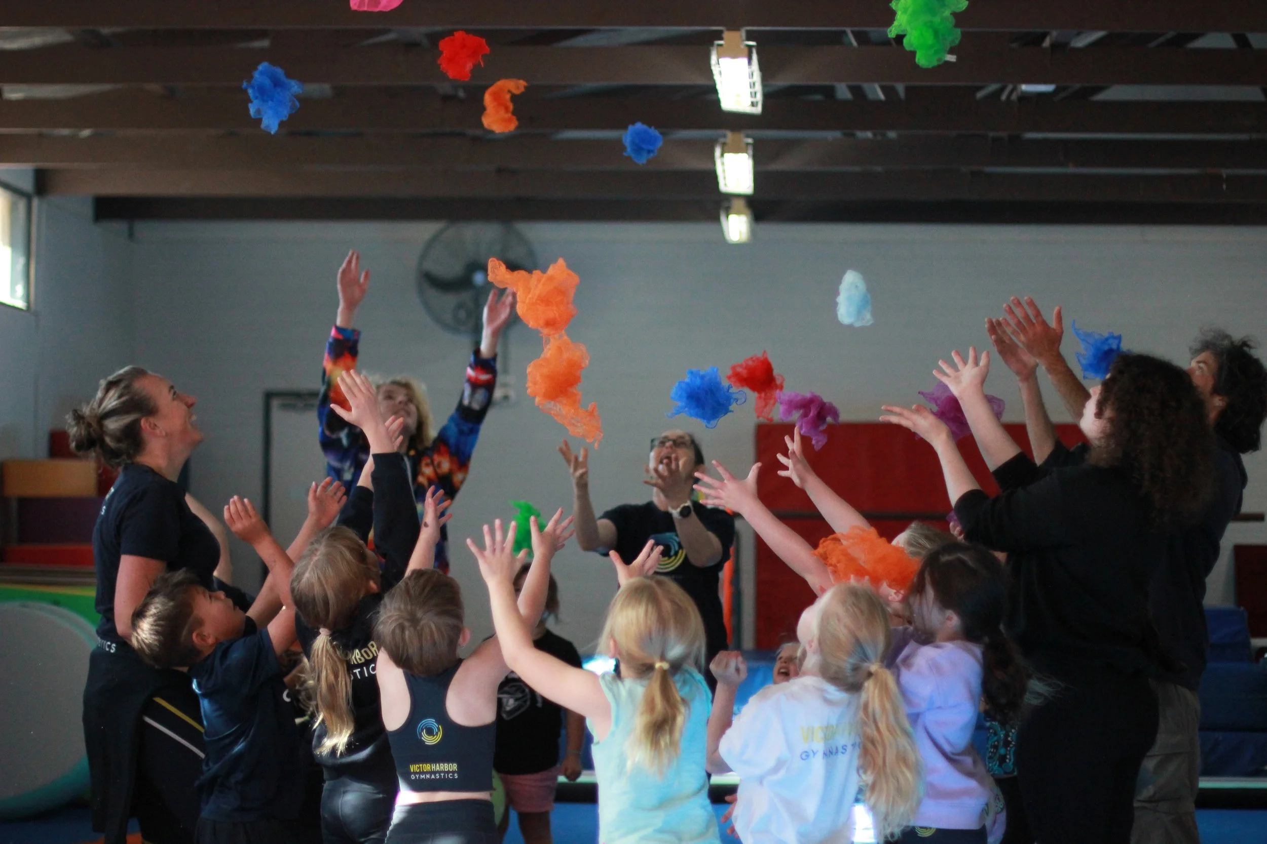 VHGC gymnasts throwing coloured scarves into the air
