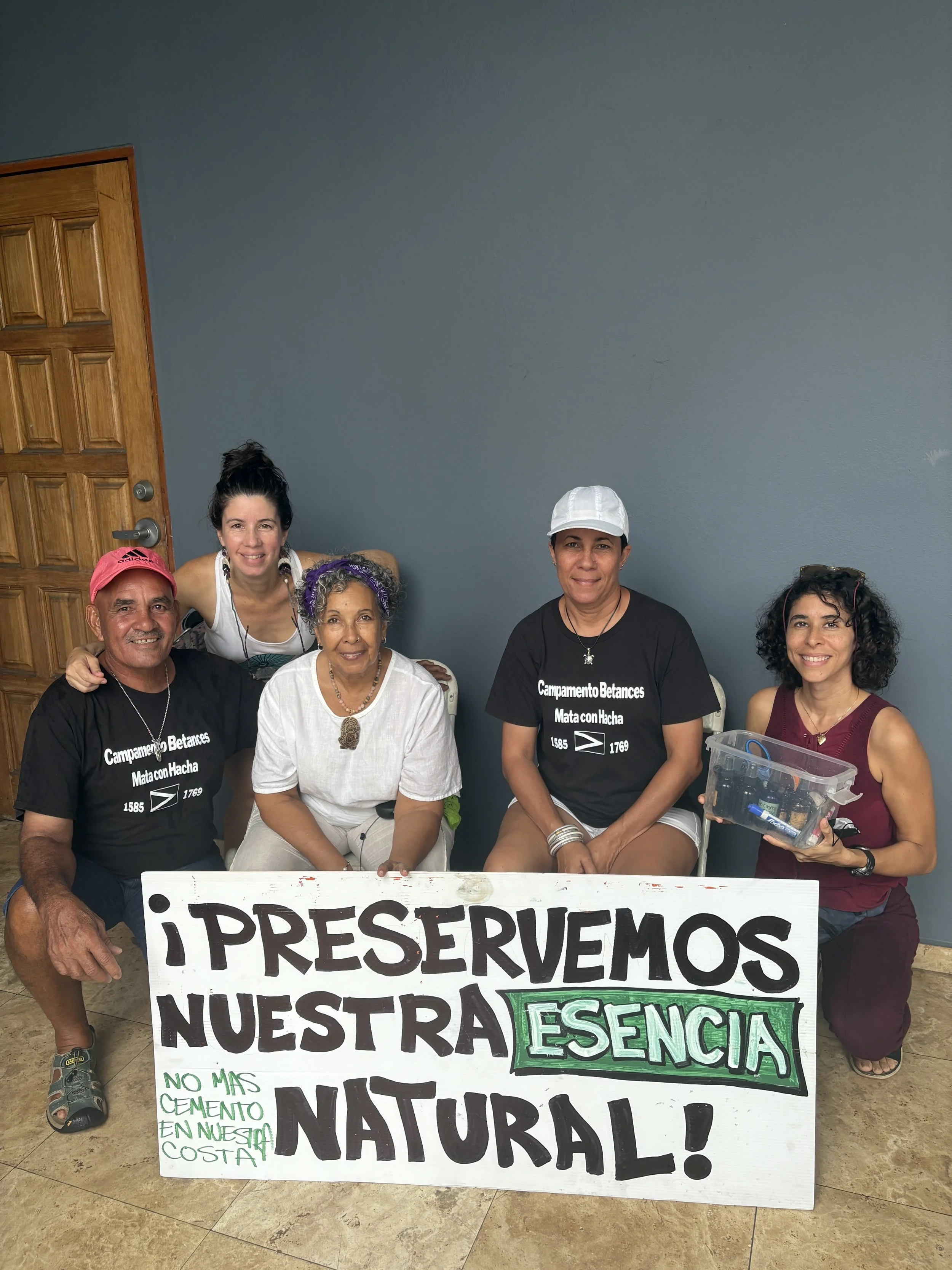 Grupo de personas sosteniendo cartel en una manifestación que dice: '¡Preservemos nuestra existencia natural! No más cemento en nuestra costa'.