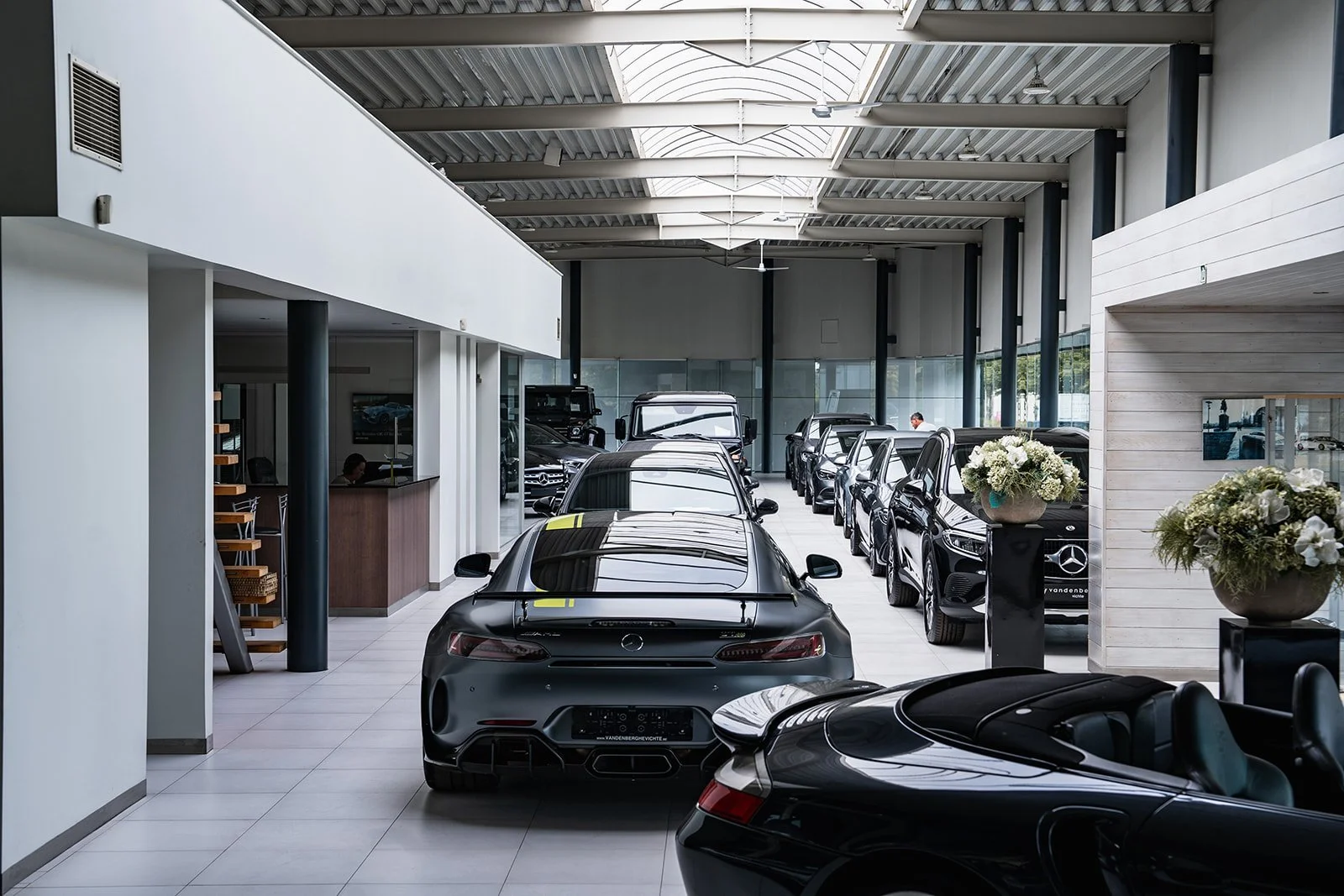 Een grijze Mercedes-auto in een autodealer showroom.