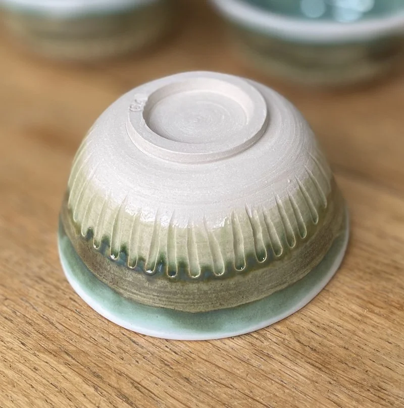 unique hand built medium bowl. Glossy teal green and white glaze with carved detail. White stoneware, unique