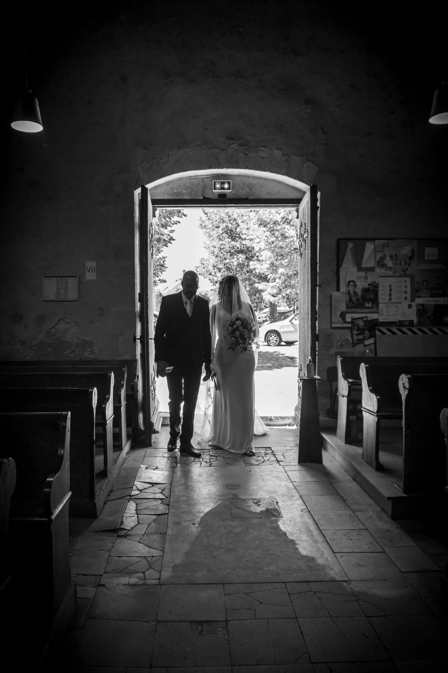 Entrée des mariés dans l’église, silhouettes en contre-jour lors de la cérémonie de mariage en Touraine