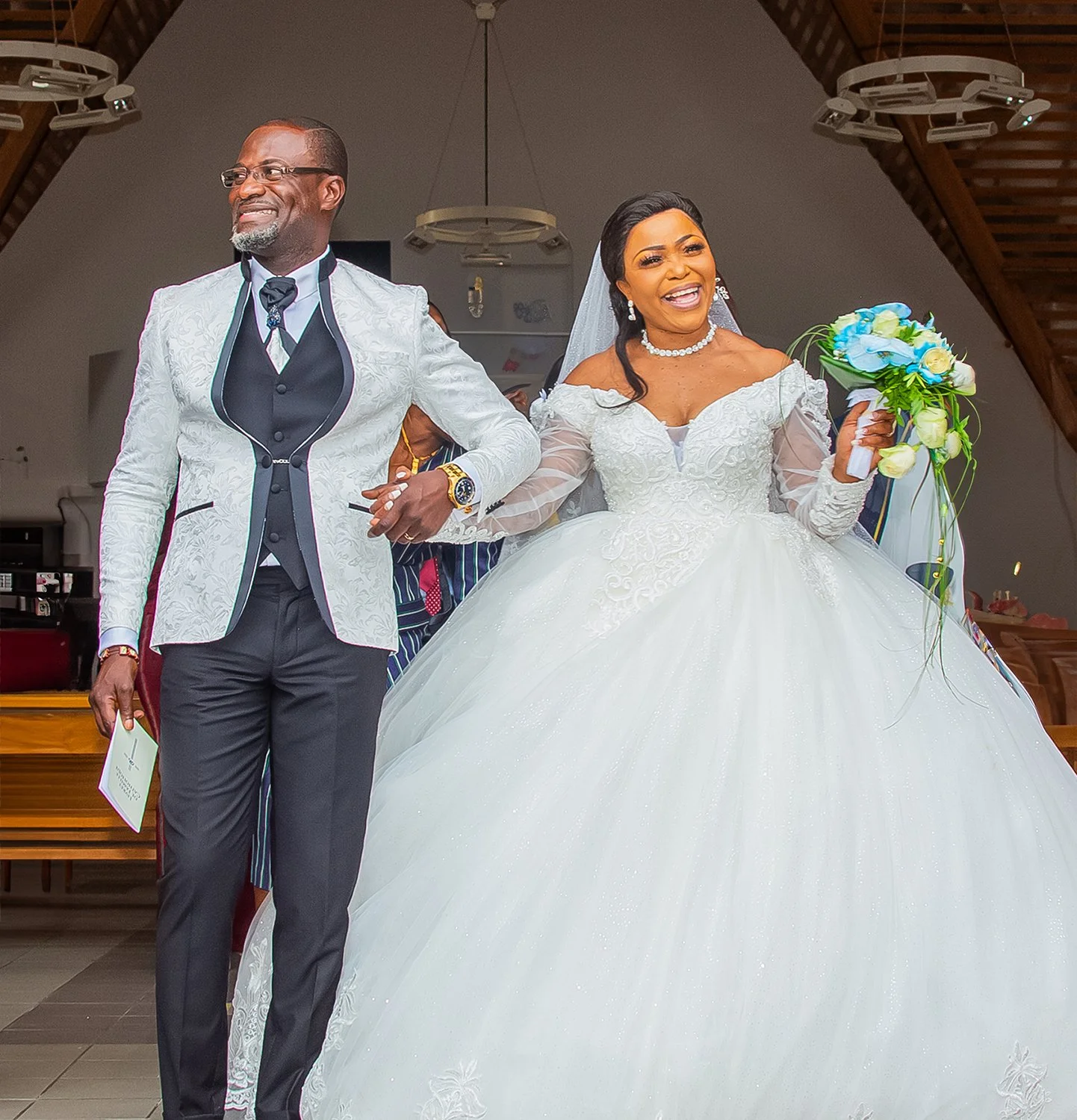 Sortie des mariés main dans la main, sourire et émotion partagée lors d’un mariage à Tours