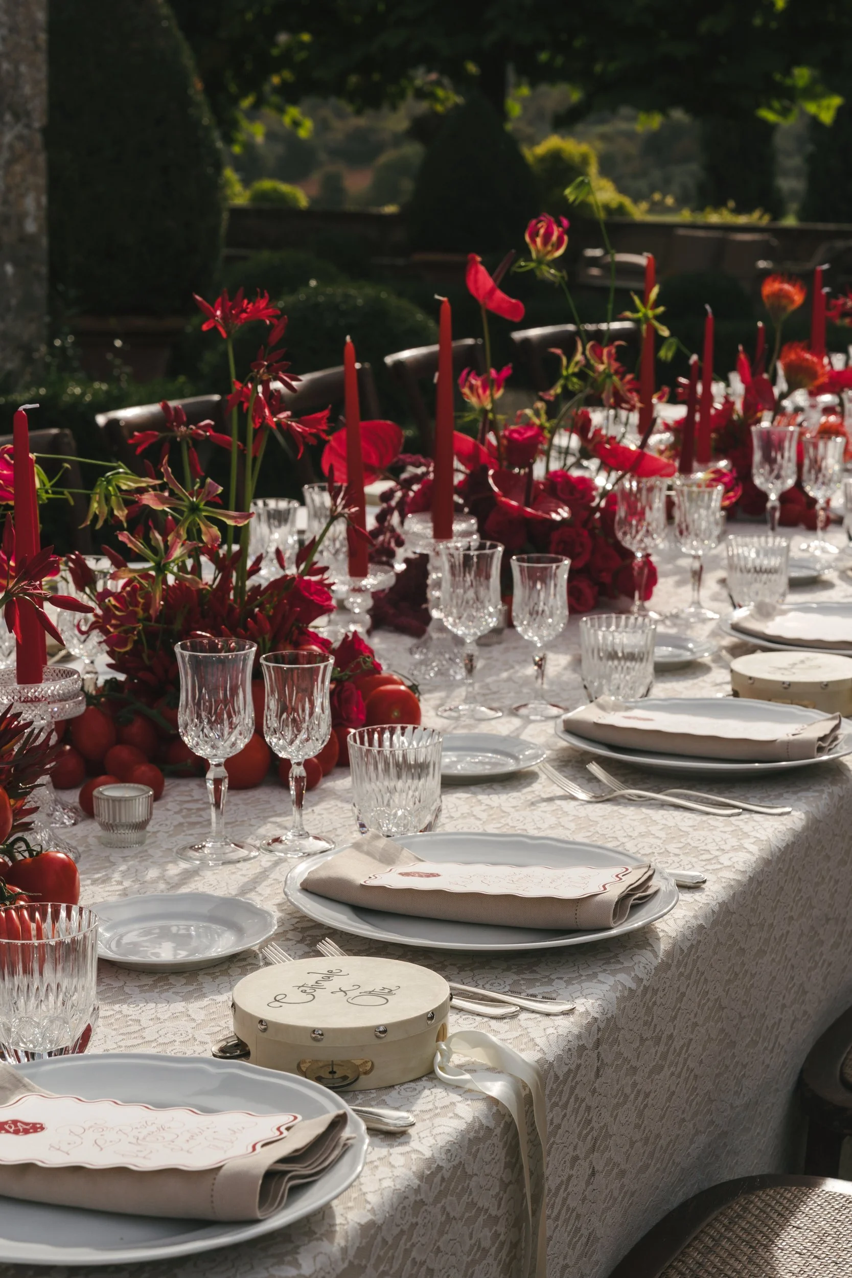Deep red autumn tablescape with red tapers, cut-crystal glassware and a lace tablecloth at a Villa Cetinale welcome dinner