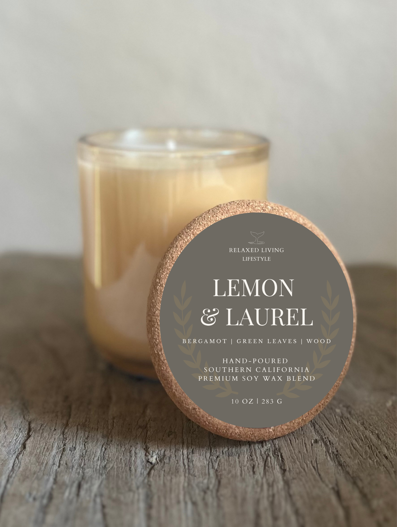 Unlit Lemon & Laurel 10 oz Champagne Glass candle with cork lid styled in front, luxury soy candle with long lasting citrus and musk scent